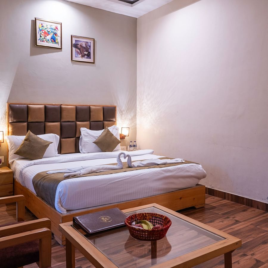 Cosy twin-bed room with wooden floor and wall decor at The Tattwaa Corbett Spa & Resort.