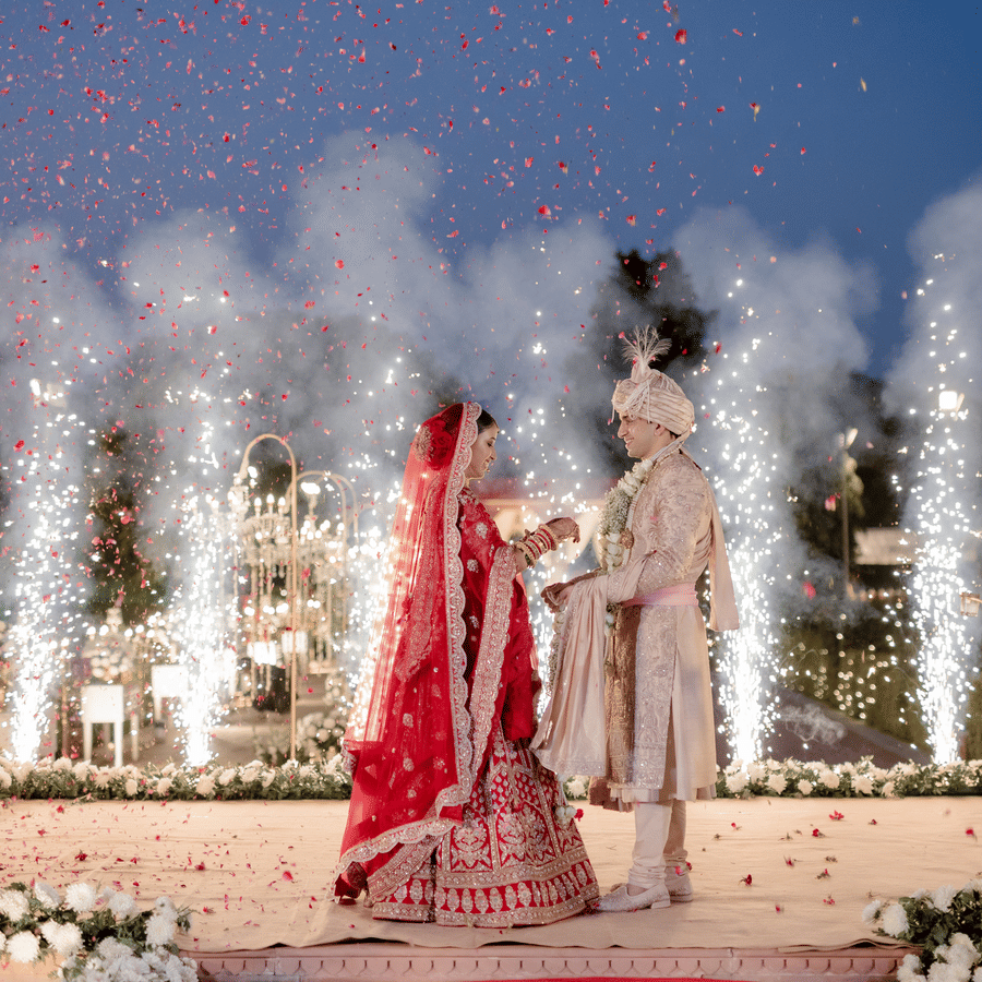 Bride and groom making a grand entrance with fireworks during a night wedding at Umaid Palace.