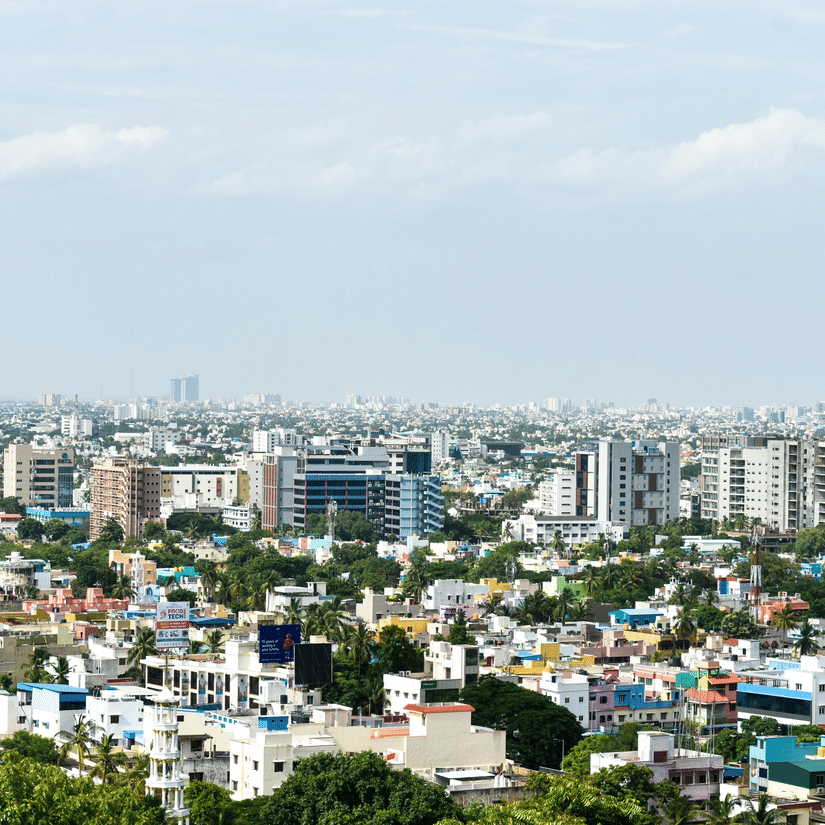 Panoramic daytime view of Chennai skyline with residential neighbourhoods, commercial buildings, and urban cityscape stretching into the distance