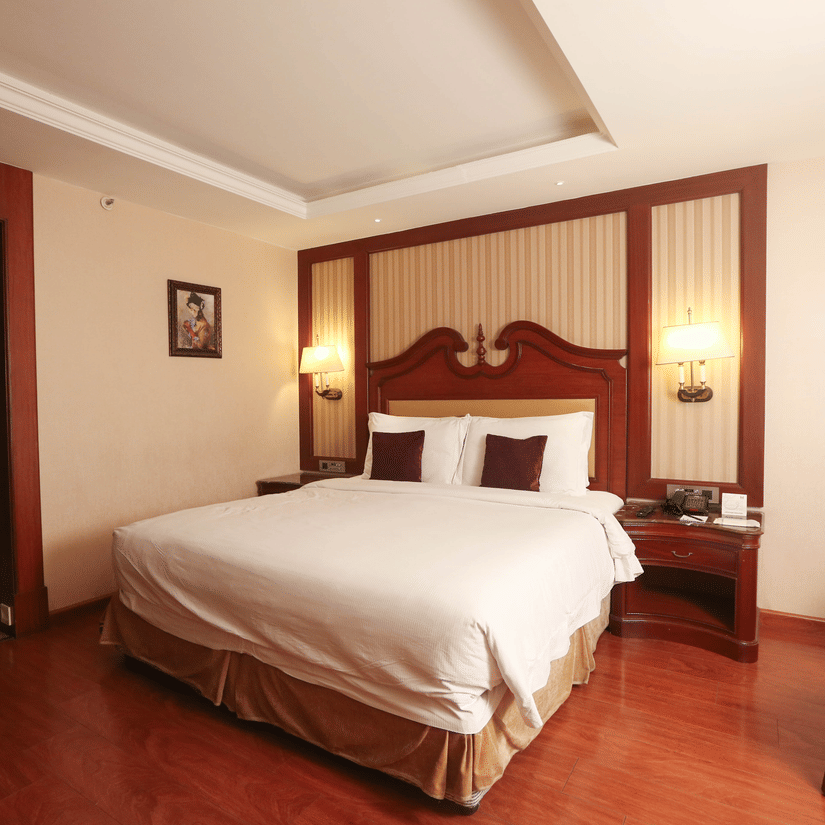 Well-appointed king bedroom with ambient lighting, plush bedding, and contemporary interiors for short stays in Chennai | Hablis Hotel Chennai
