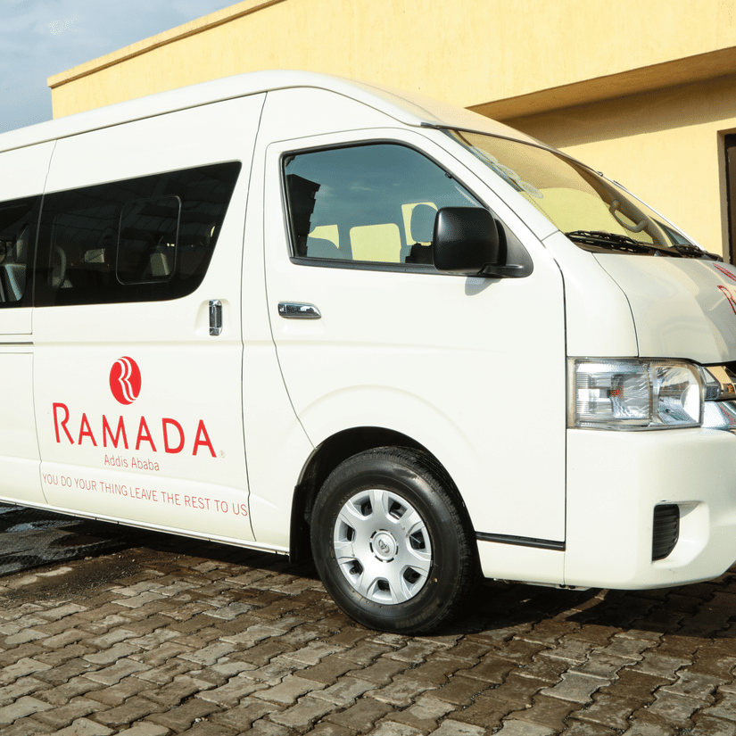 A close up of a white van with ramada logo on it parked next to a building - Ramada by Wyndham Addis, Addis Ababa