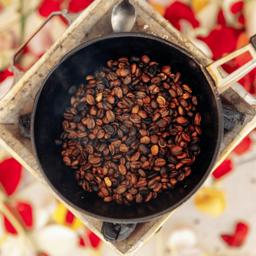 Coffee beans being roasted on a flat pan as part of the traditional coffee ceremony.