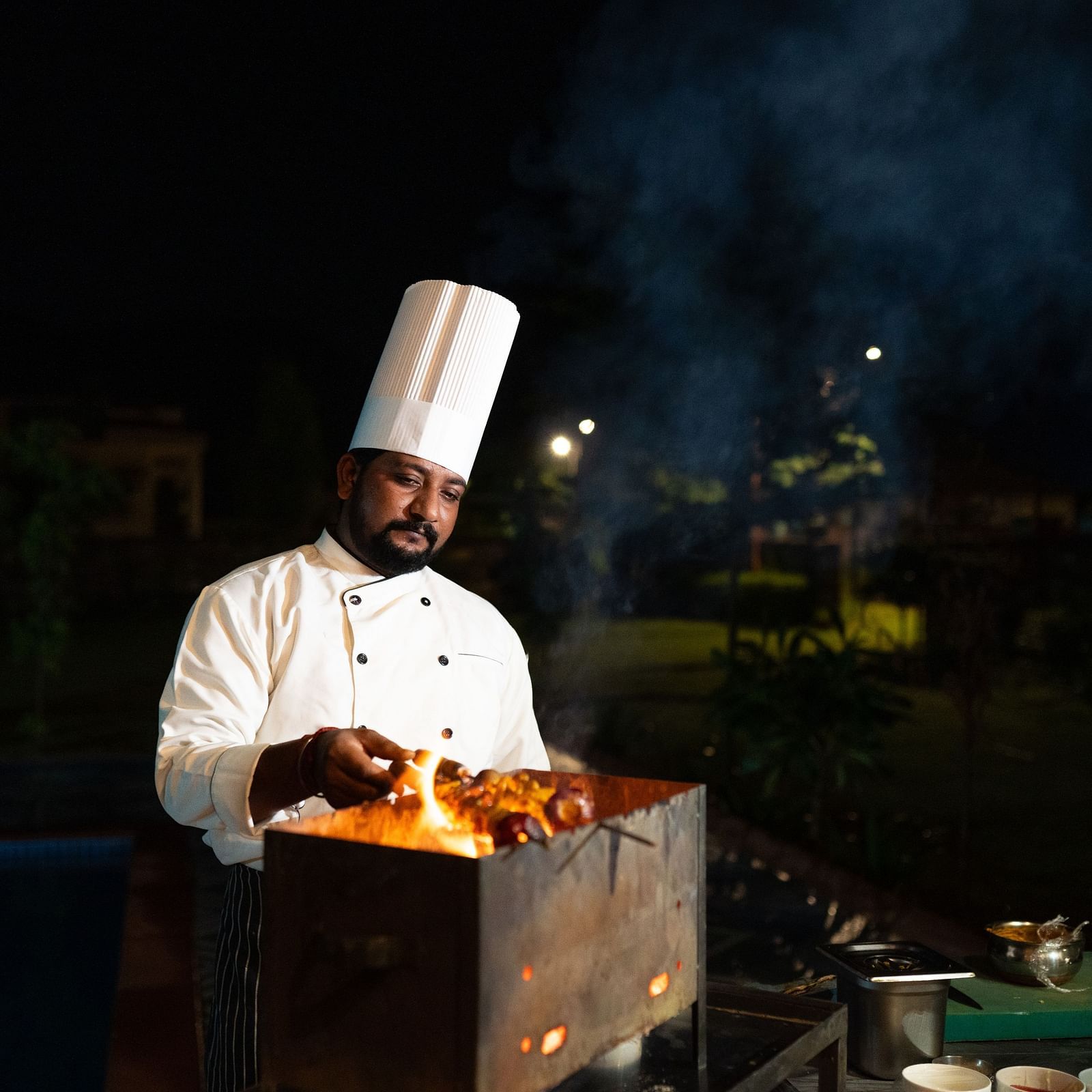 Image of a man cooking food over a fireplace at Aanandam Resort & Spa, Pushkar