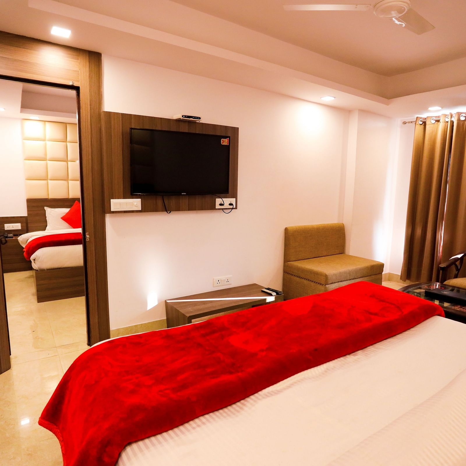 Image of a room with a bed and a door in front connecting to the next room in front at Amara Hill Queen, Mussoorie.