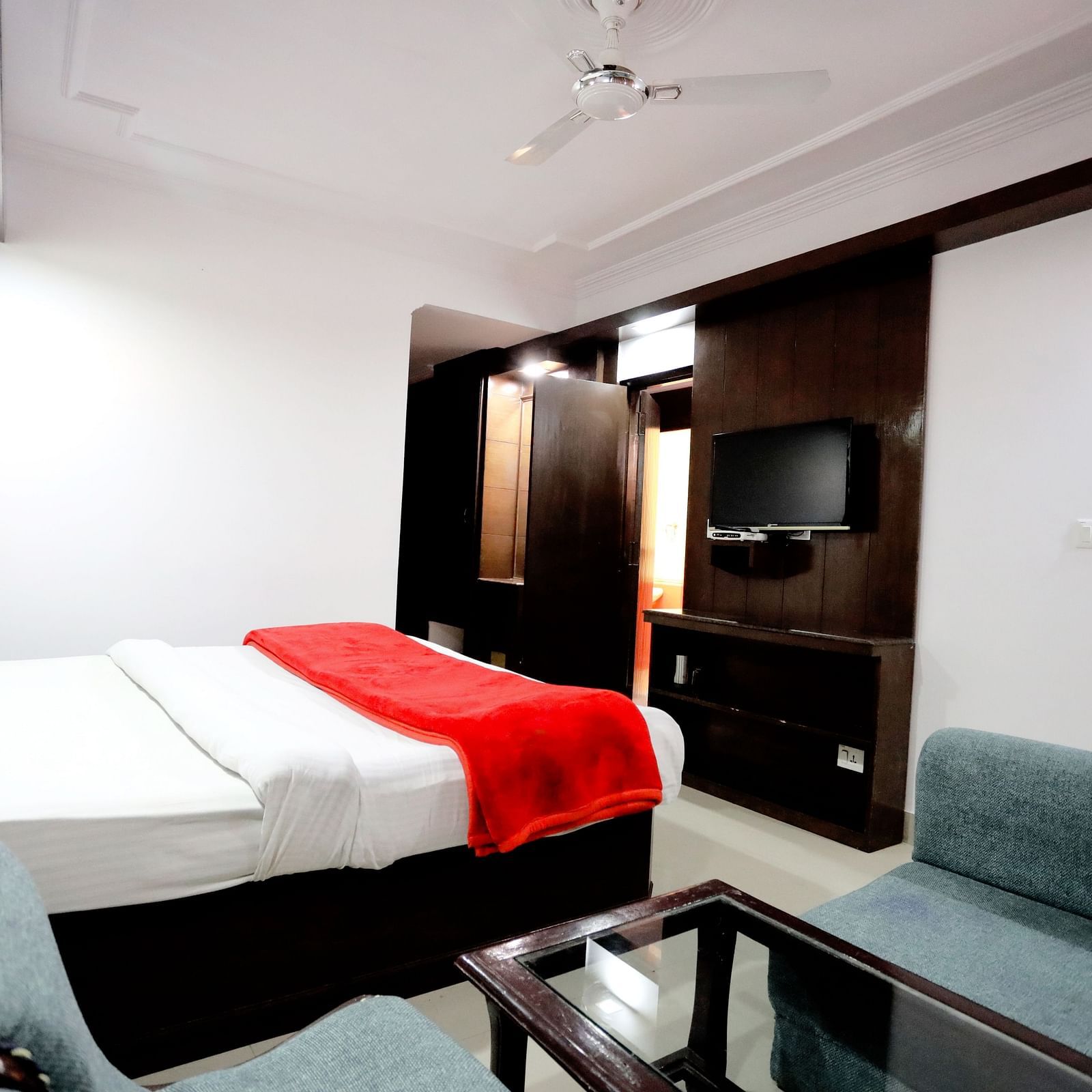 Side view of a room with a bed and a sofa on the side with a coffee table in front of it at Amara Hill Queen, Mussoorie.
