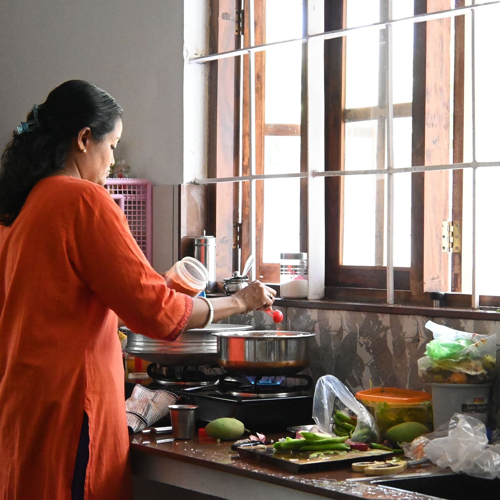 A women cooking in the kitchen at Ananda Holiday Home, Wayanad