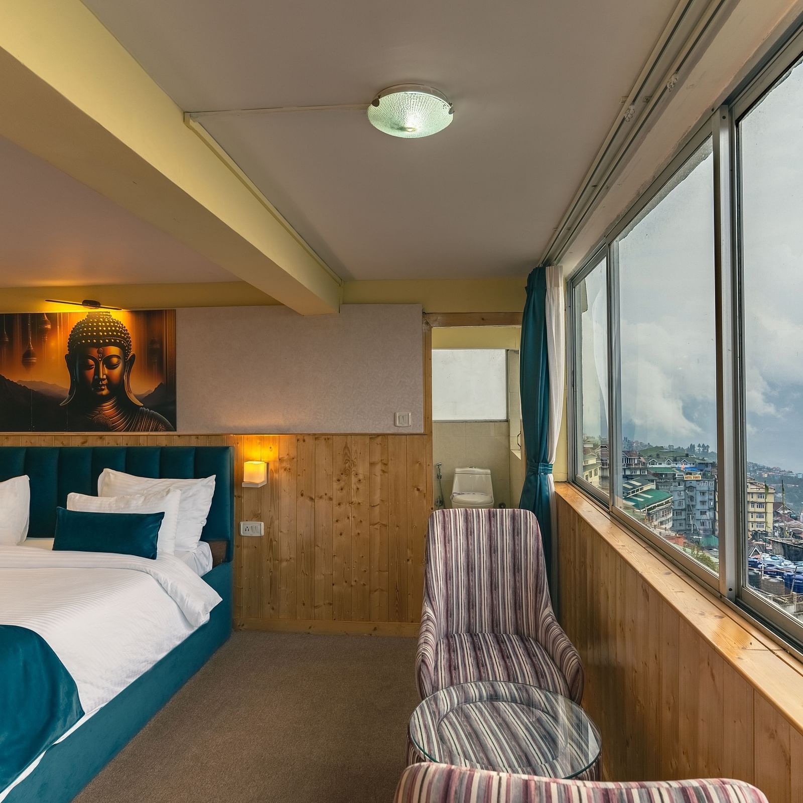 Image of a room with bed and seating area and large glass at Seven Seas