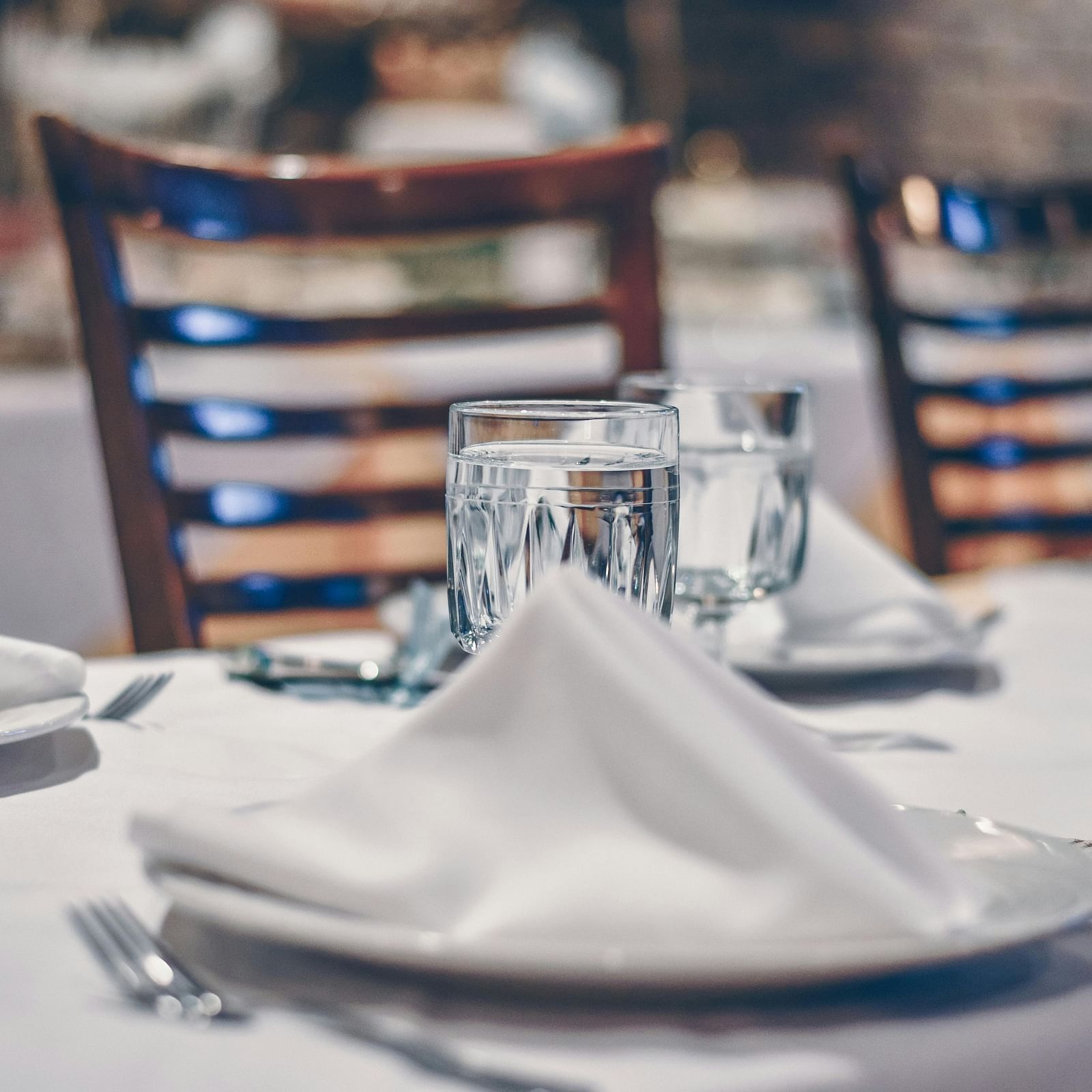 an image of a dining space with a glasses and plates kept on the table
