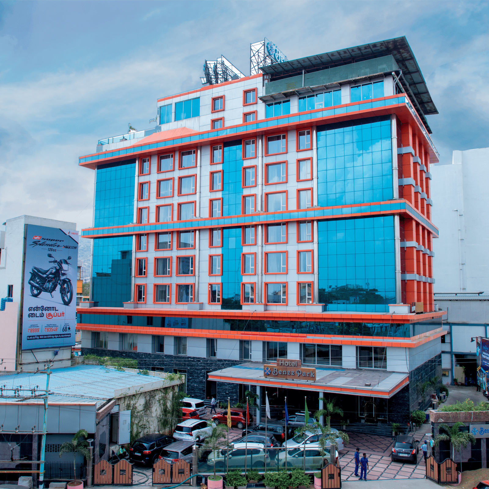Facade shot of Benzz Park, Vellore, featuring the entrance on the bottom of the building along with a cloudy sky in the background.