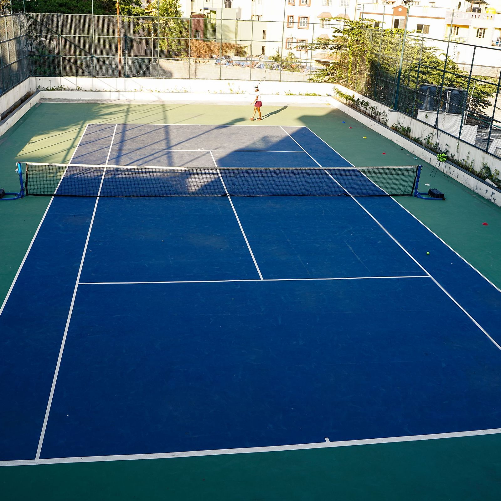  A vibrant outdoor tennis court with blue and green playing surfaces, ready for a match at BNGV Grandeur Hotel and Banquets.