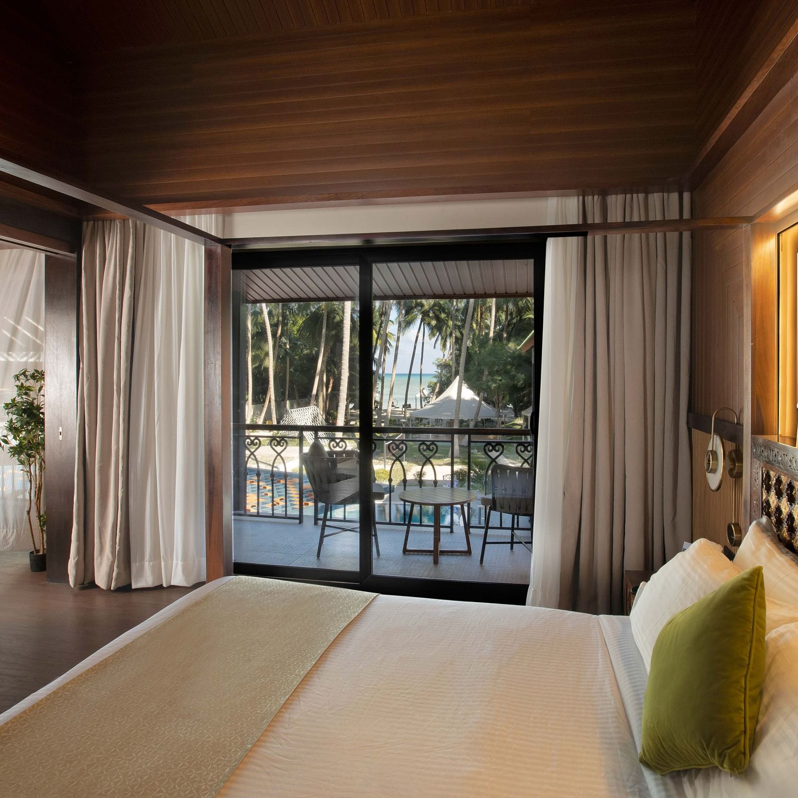Image of the doorway to the balcony taken from the plush bed in Coral Teal Suite at Coral Reef Resort and Spa in Havelock