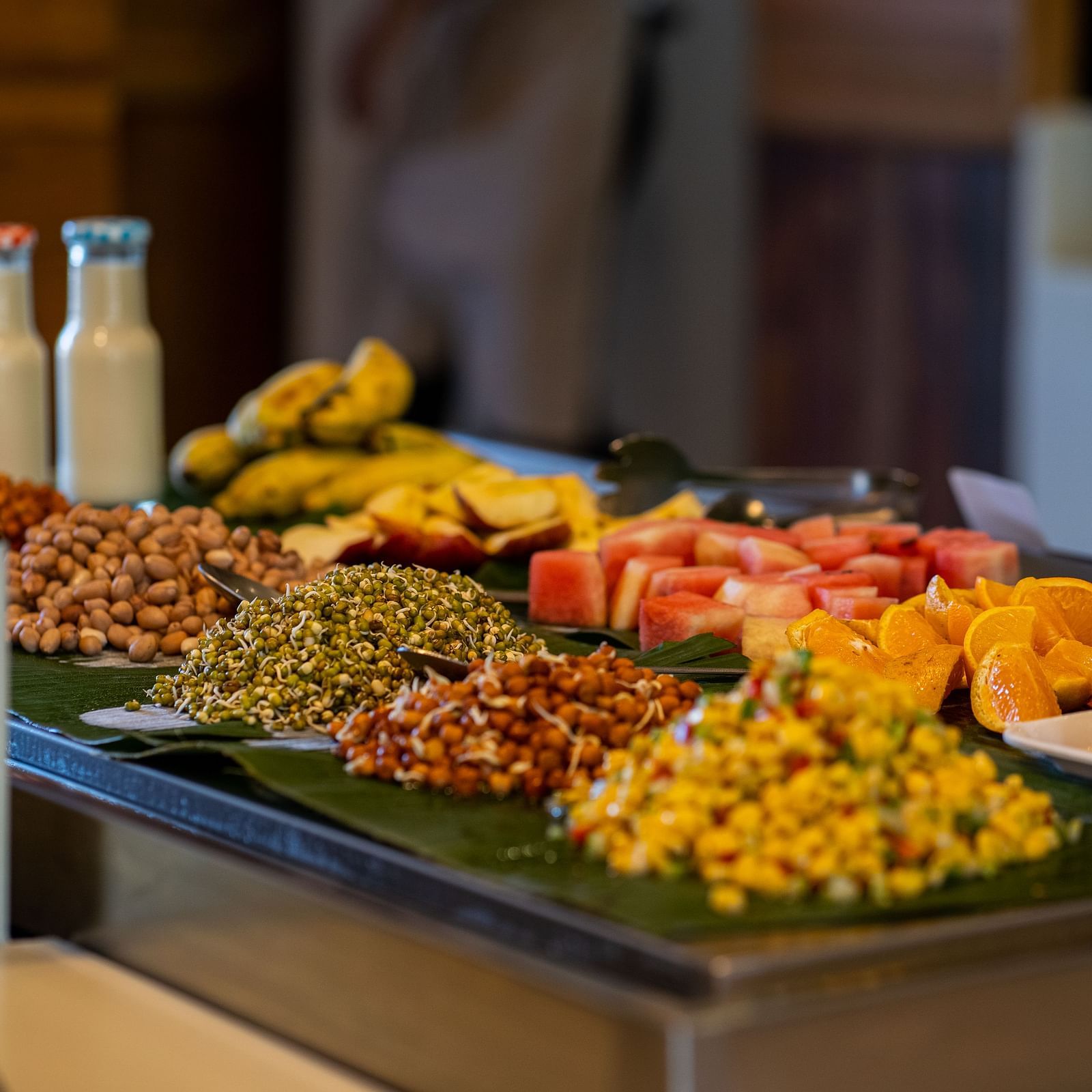 A detailed view of a buffet with assorted grains, legumes and fruits and a blurred background of the dining area - Coral Reef Resort & Spa, Havelock