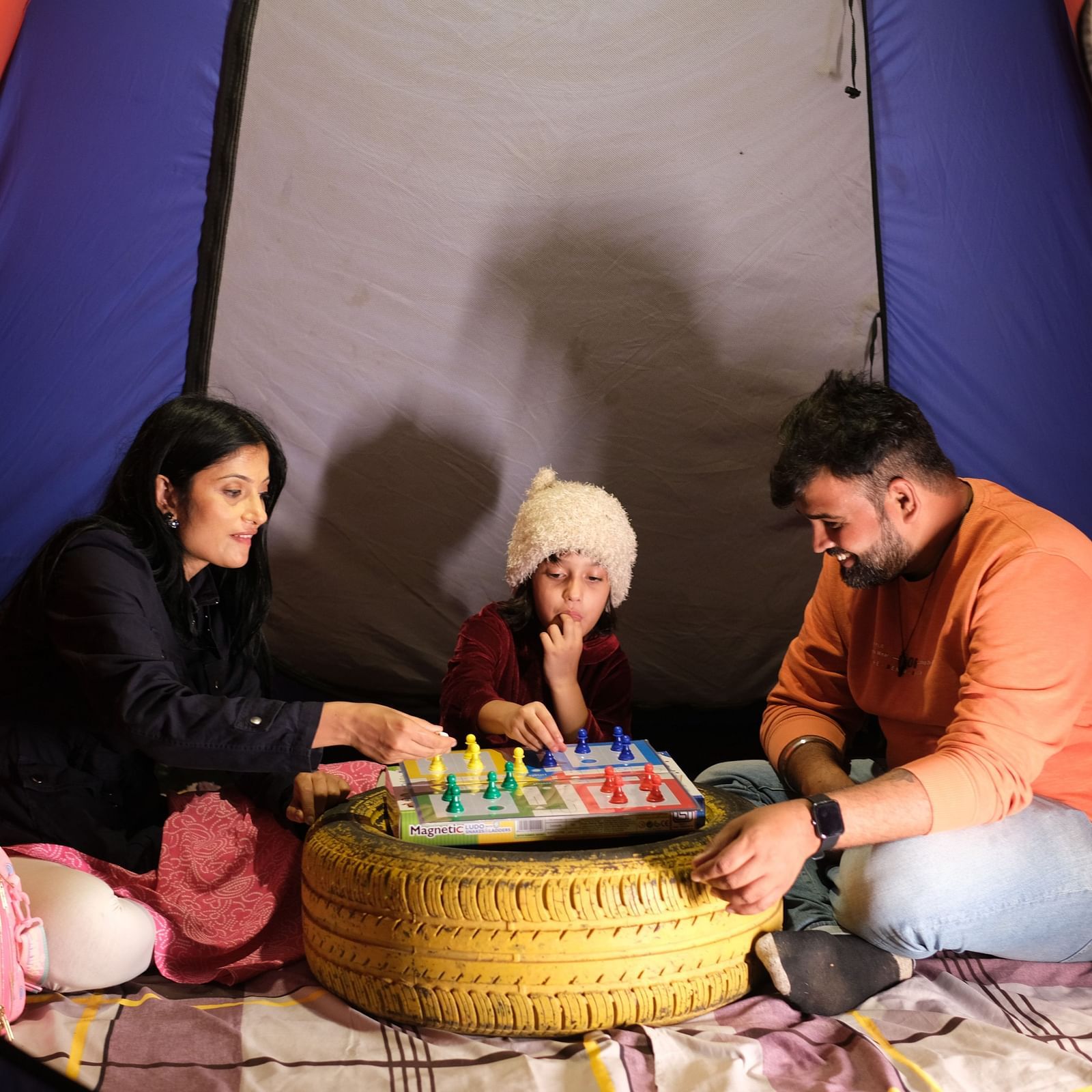Family playing board games inside a tent at night | Diamond Parks, Pune - Trekking in Pune