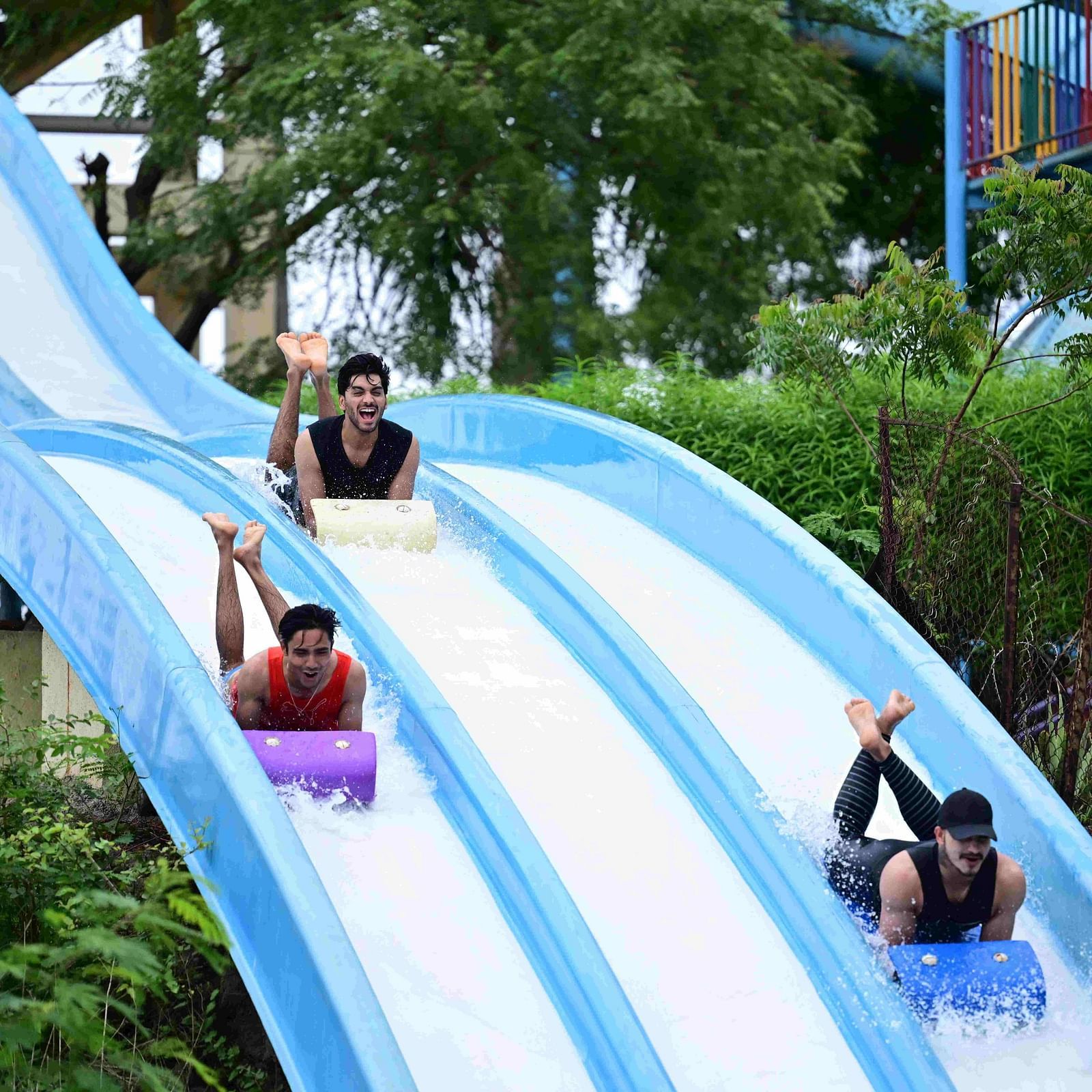people sliding down a multi-lane water slide at an amusement park | Diamond Parks, Pune 