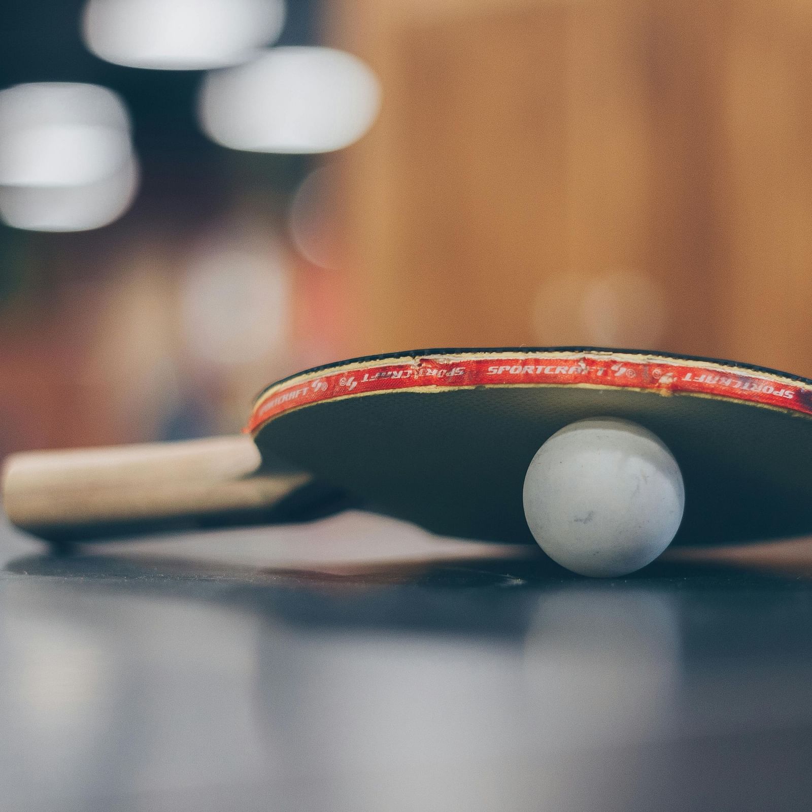 A table tennis paddle and ball on a table.