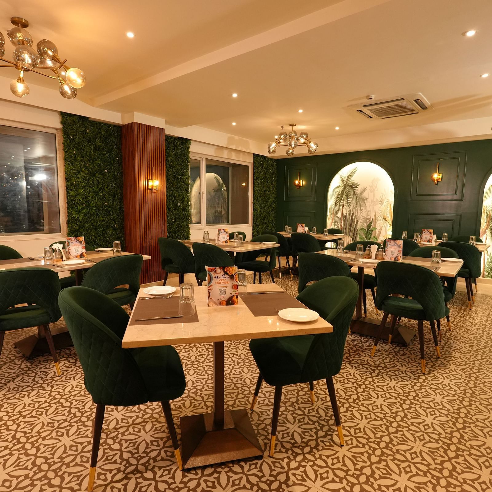 Contemporary dining area with elegant chairs and wall art at Grand Plaza Lords Inn Jammu.