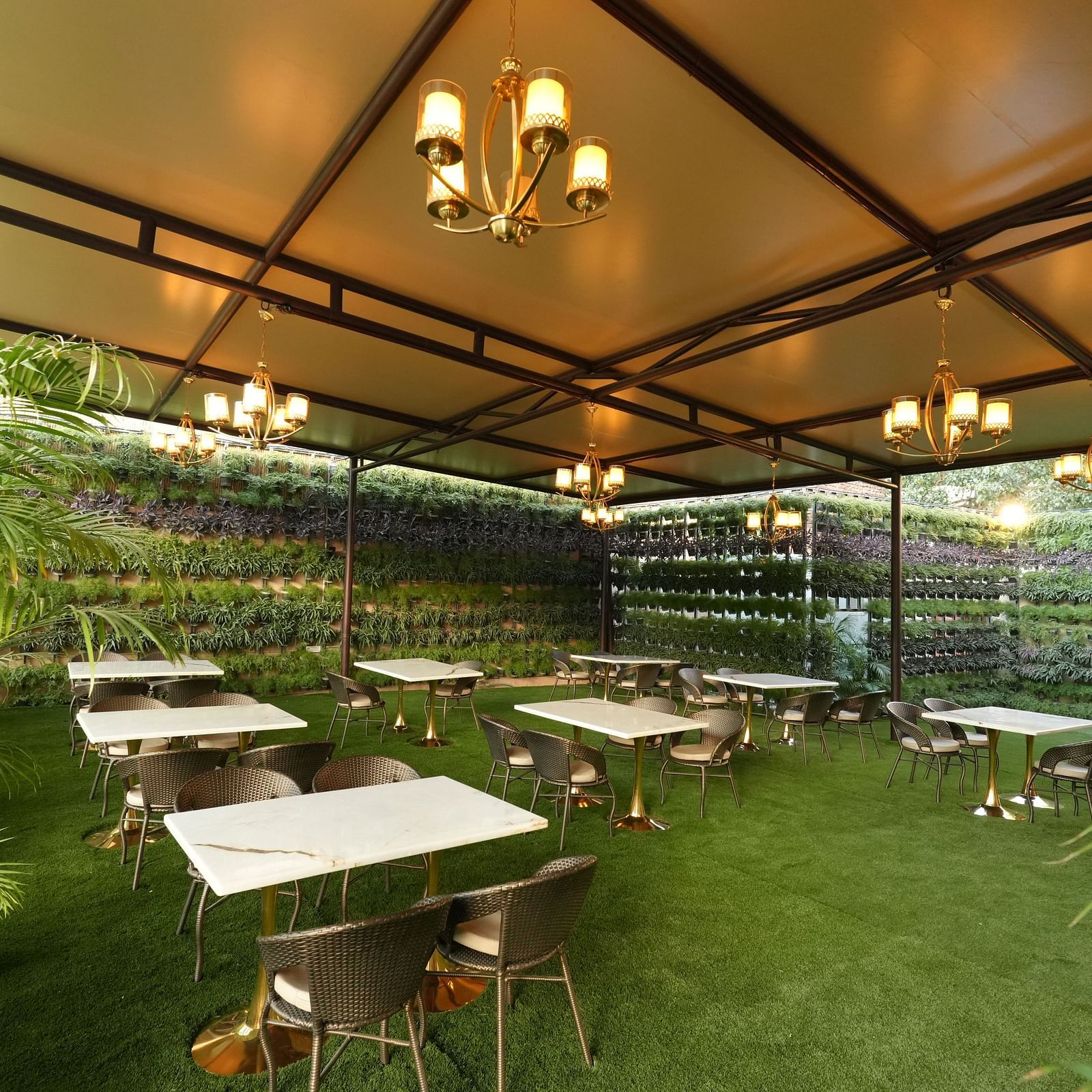 Garden dining space with canopy and greenery at Grand Plaza Lords Inn Jammu.