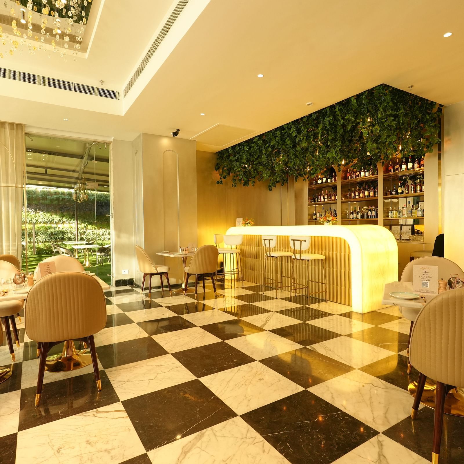 Elegant cafe-style dining area with beige chairs and sleek flooring at Grand Plaza Lords Inn Jammu.