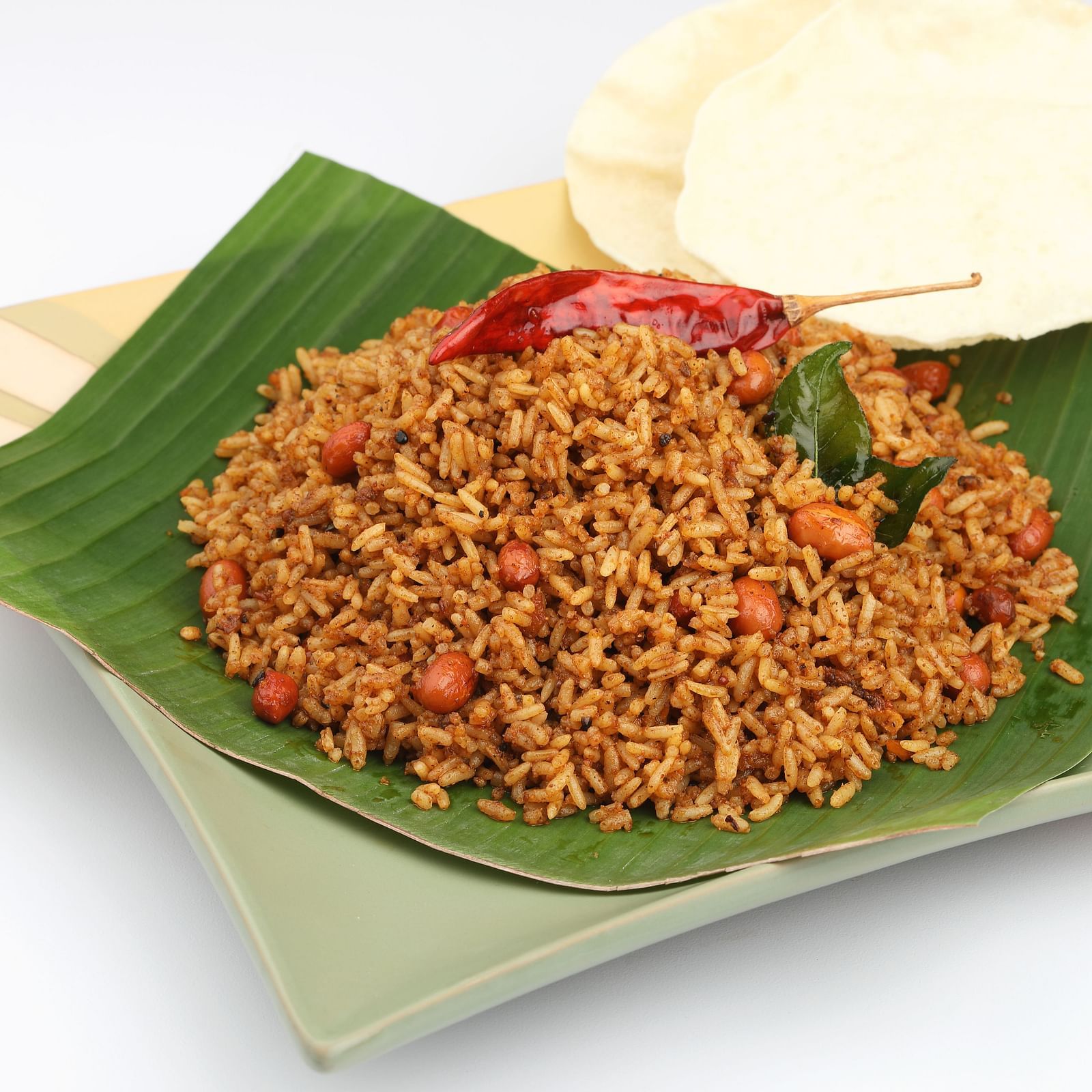 Savoury rice dish with chilli and banana leaf, an inviting South Indian breakfast.