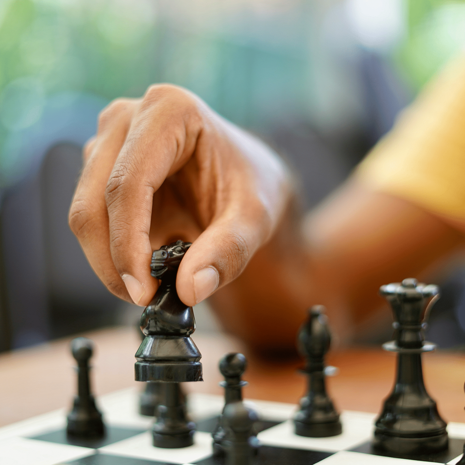 A close shot of a person holding a chess piece