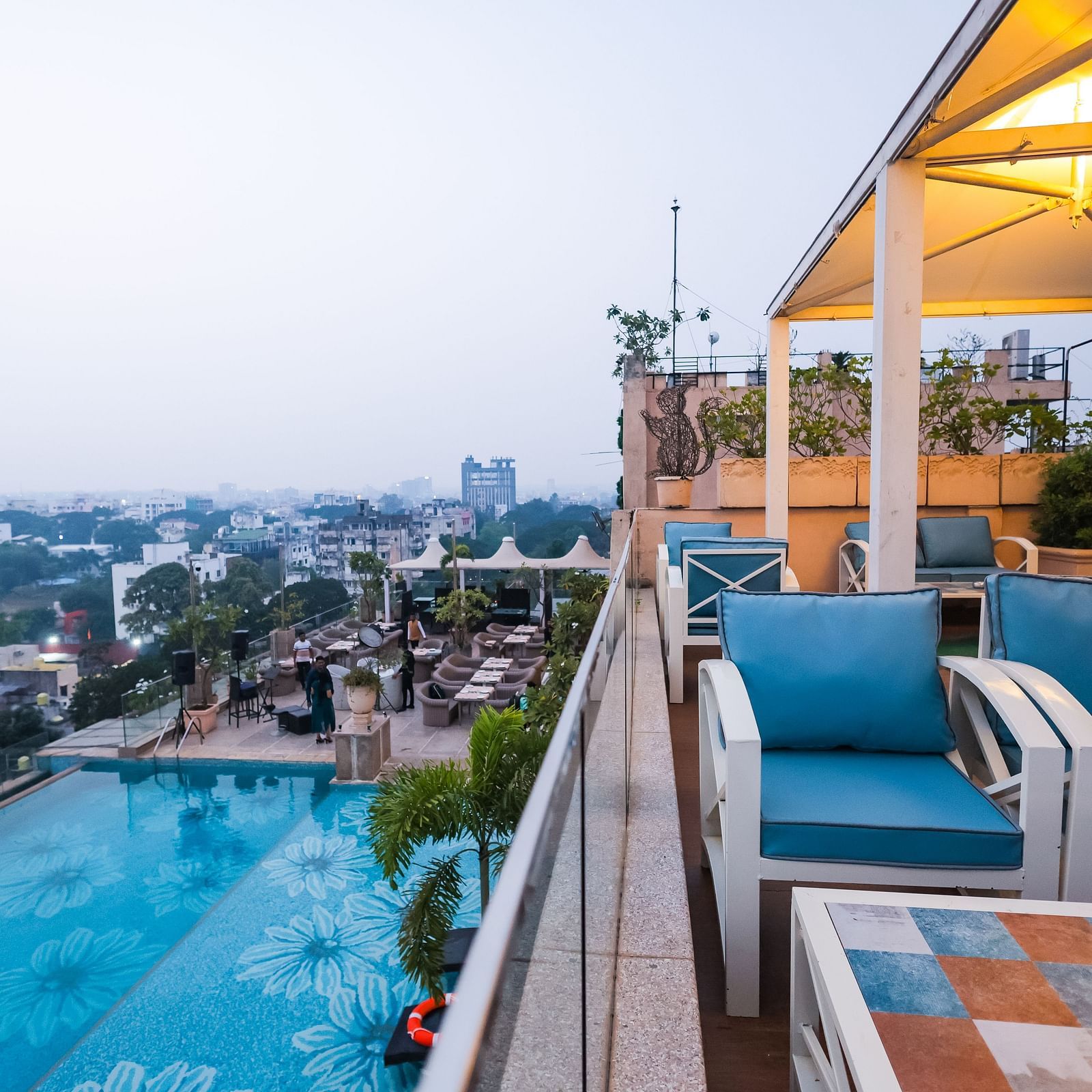 An outdoor dining space next to a pool at Hotel Ashok Nagpur.