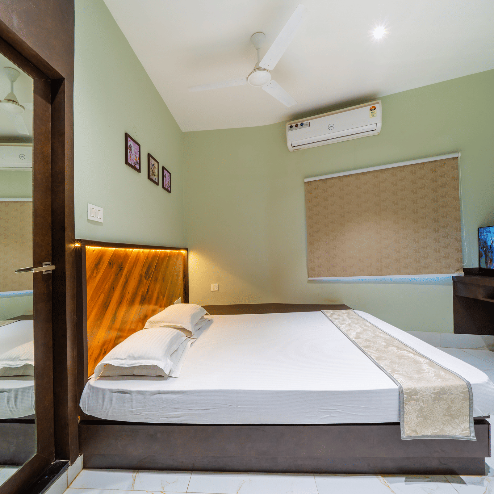 Bedroom with a double bed, a wooden headboard, a TV, and an A/C – Hotel Dolphin Puri