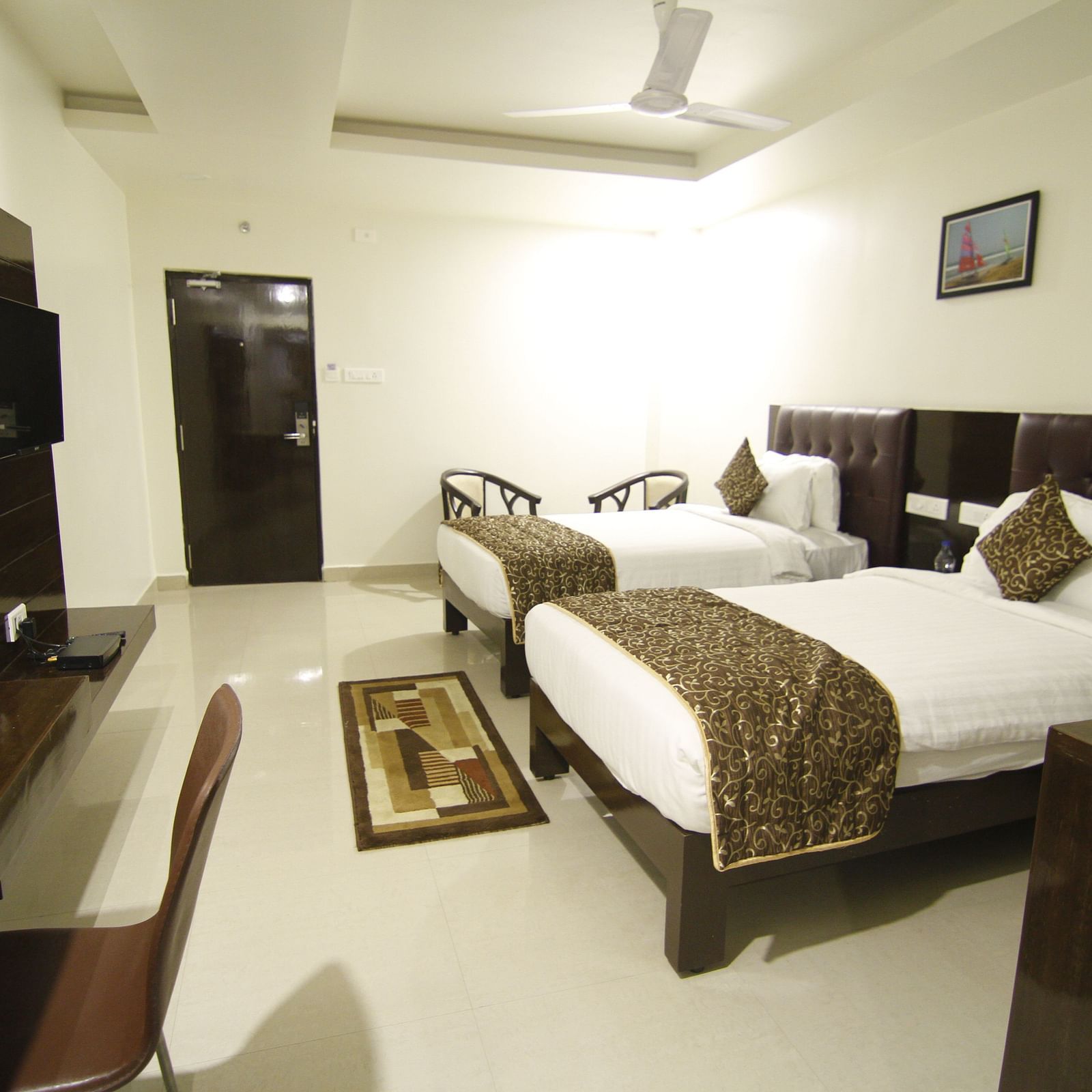 Suite with twin beds and a television in front of it at Hotel Green Apple