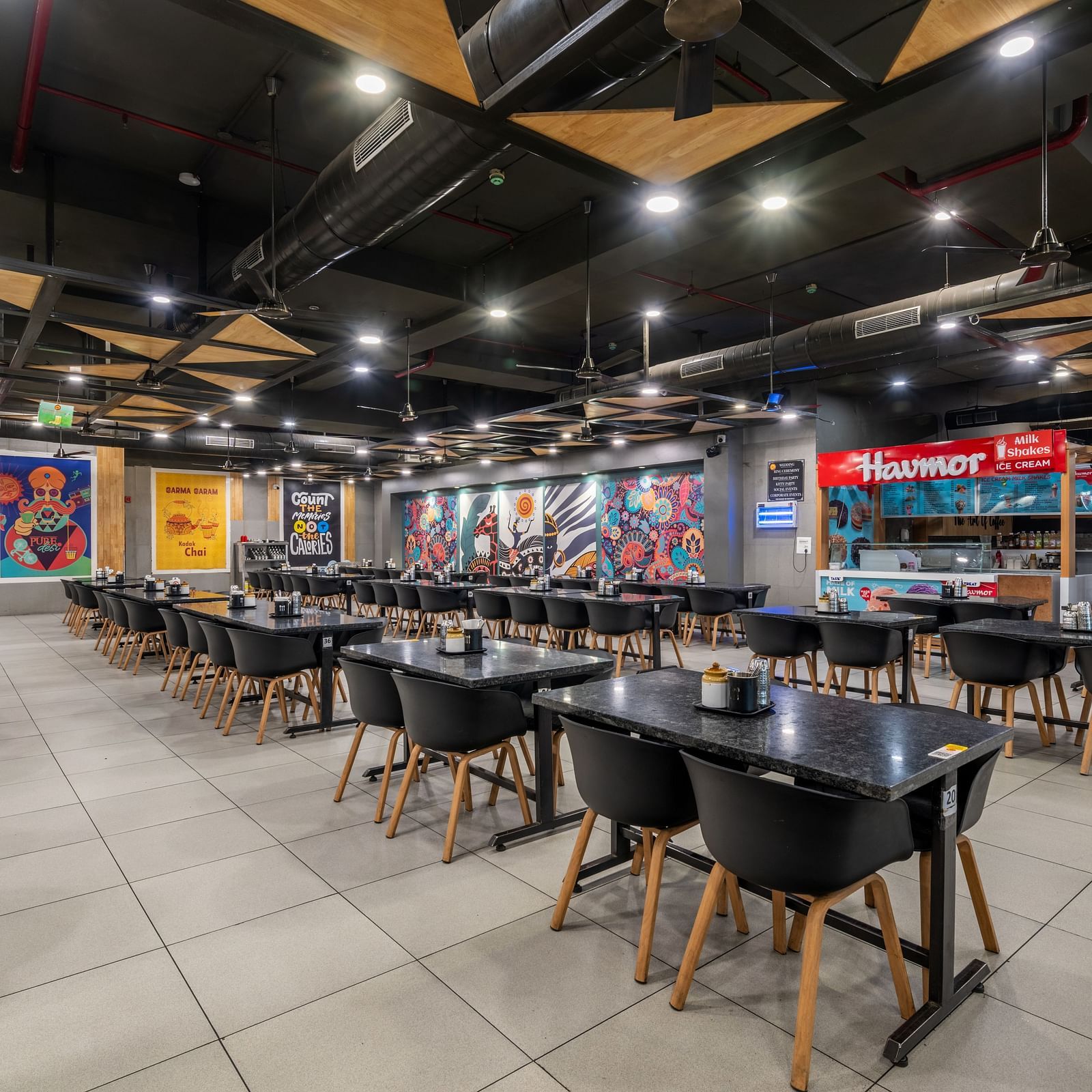 Expansive dining hall with creative murals and ample seating at Hotel Highway King, Bilaspur.