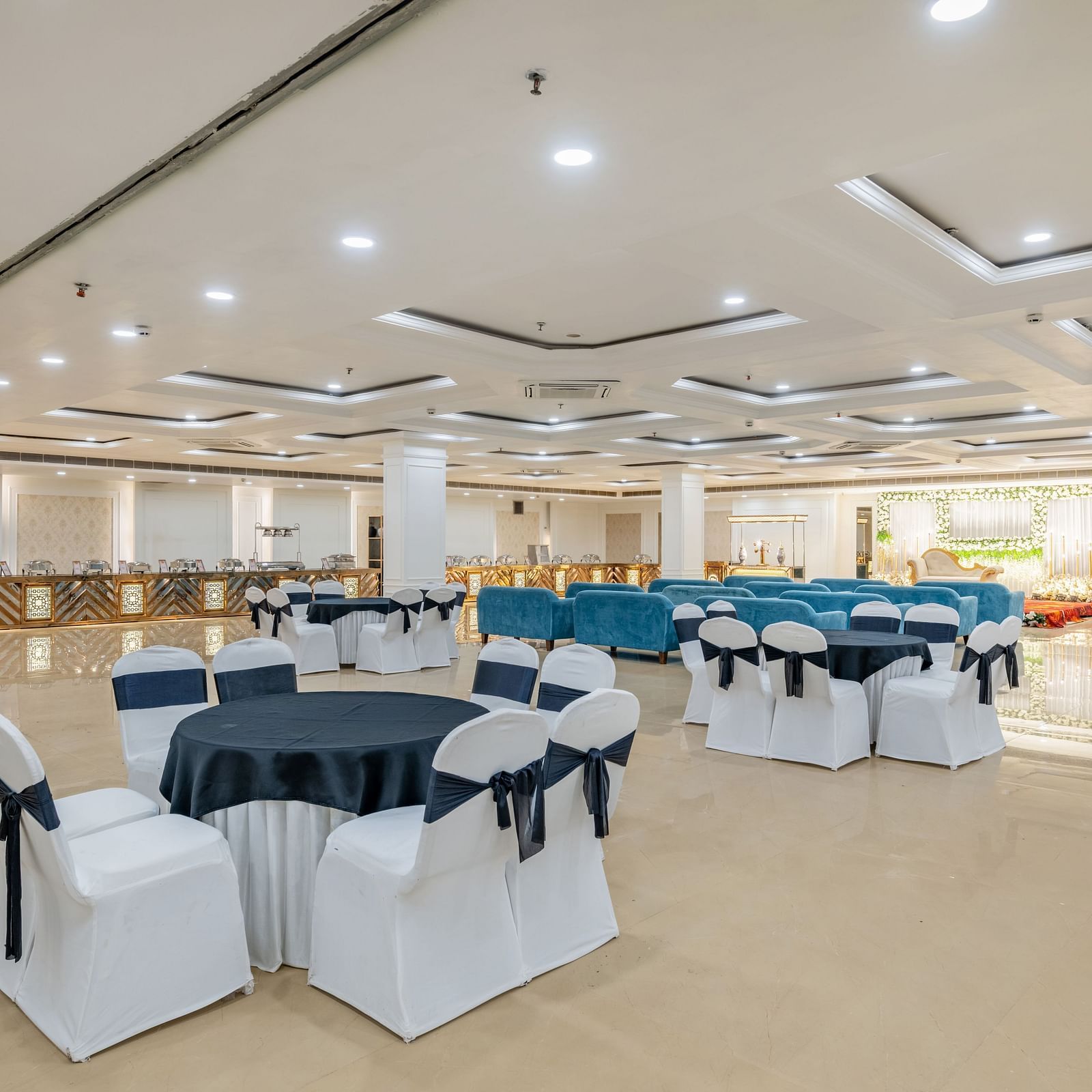 Event space with cluster seating arrangement and navy bows tied around at Hotel Highway King, Bilaspur.