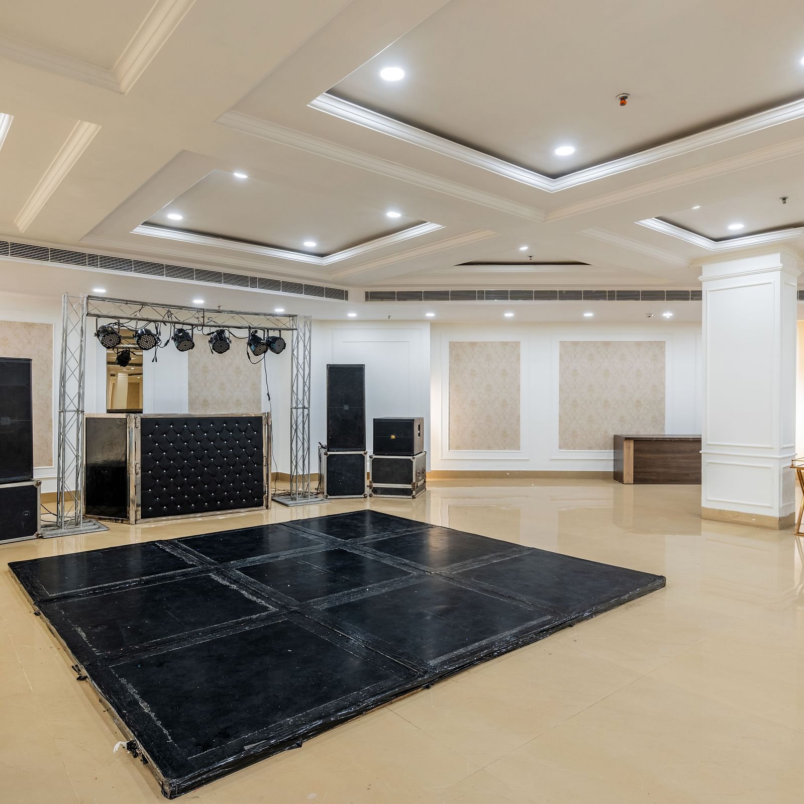 Banquet hall with a stage and audio-visual setup ready for events at Hotel Highway King, Bilaspur.