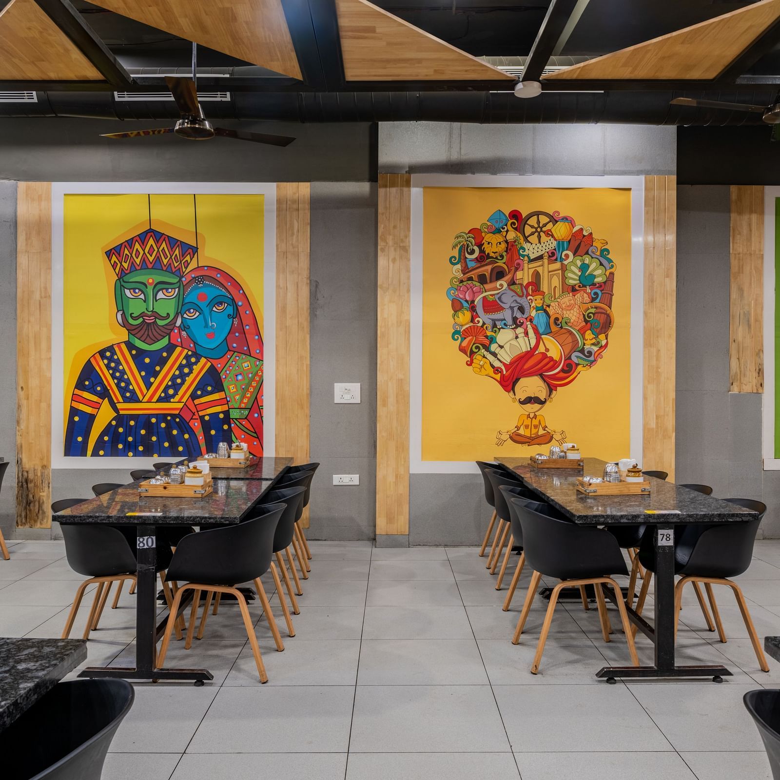 Pop-art style murals and twin seating near wall decor at Hotel Highway King, Bilaspur.