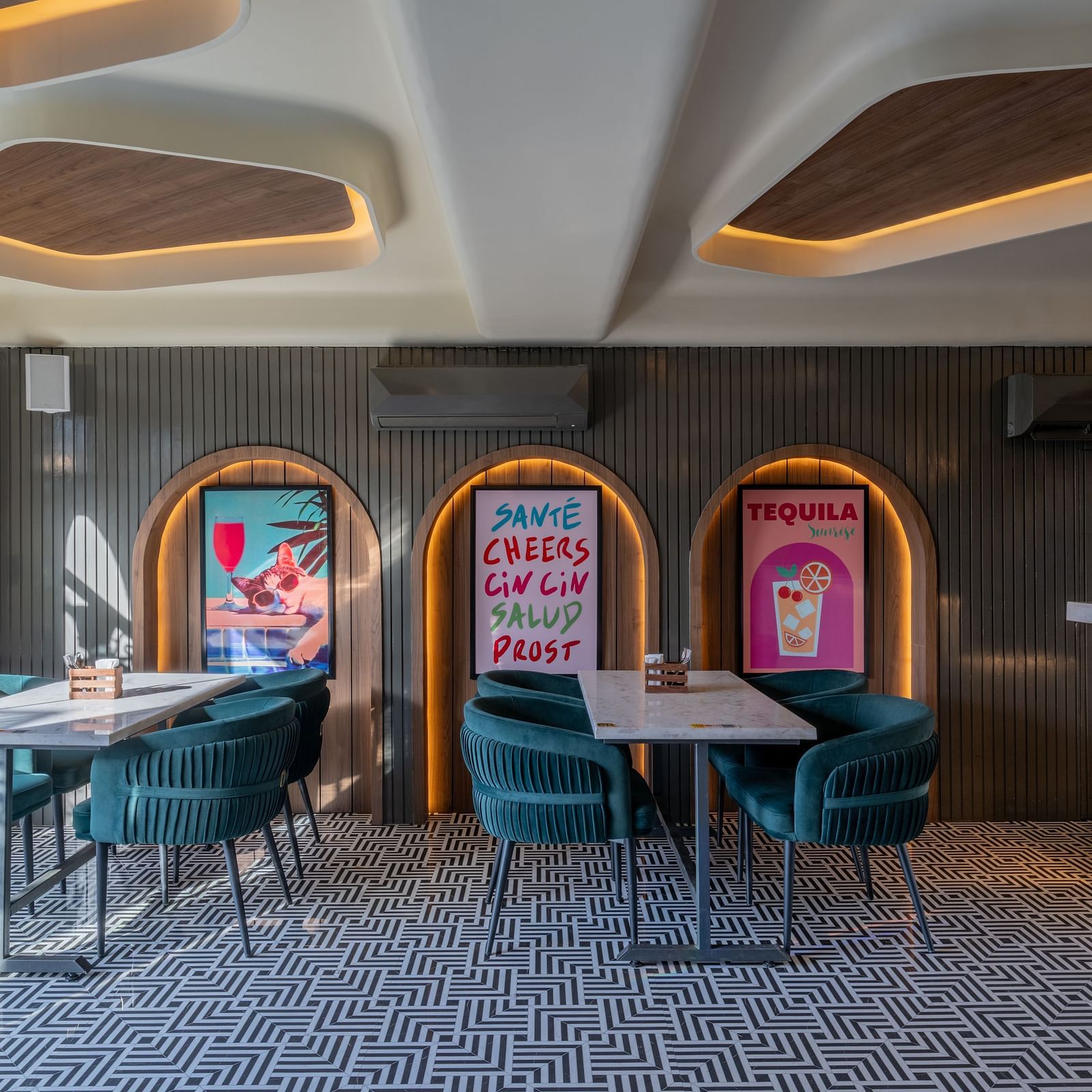 Indoor dining area with green chairs, wall arts, and tiled flooring at Hotel Highway King, Jaipur.