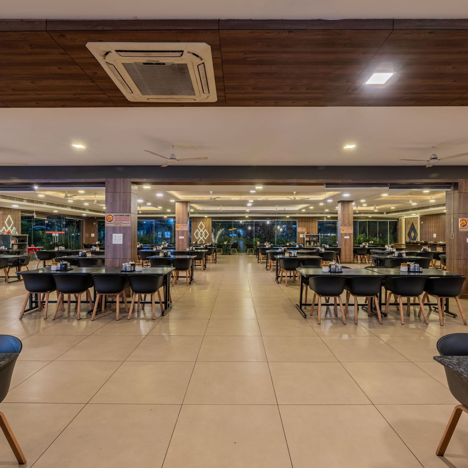 A wide shot of the grand, empty dining room within Hotel Highway King Shahpura.