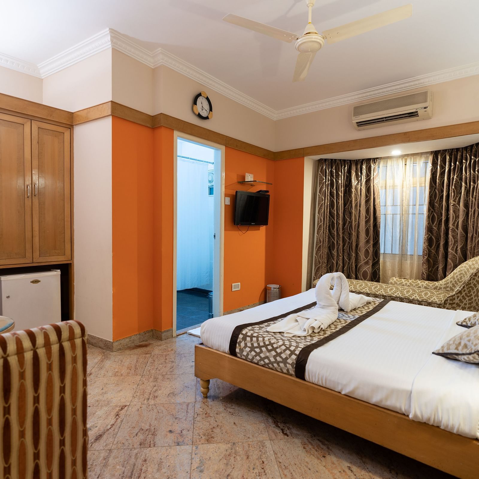 a double bed with a tv opposite it inside one of the rooms - Hotel Pai Comforts, JP Nagar