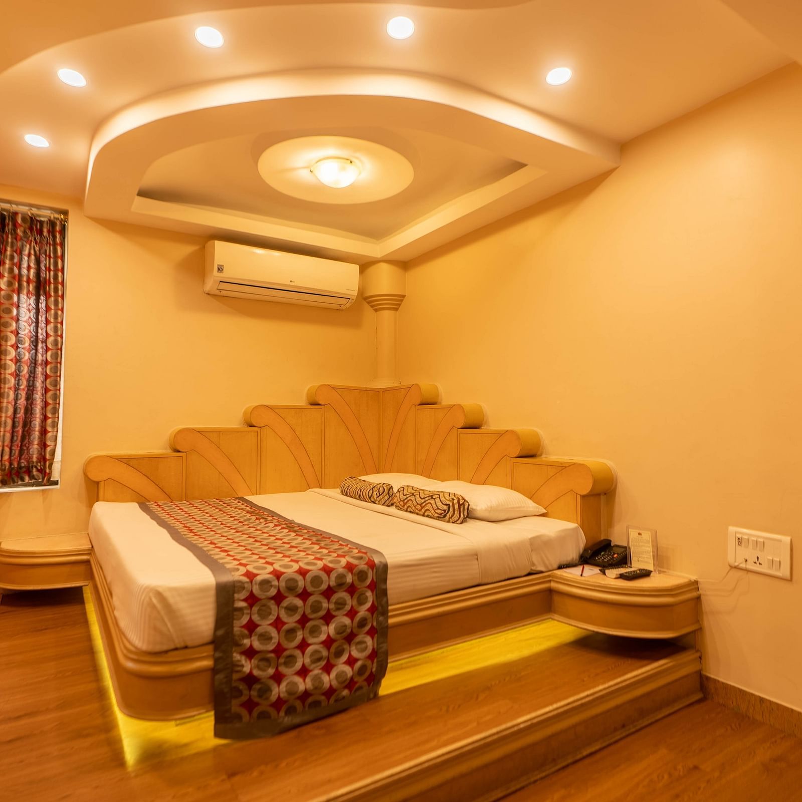 The suite at Hotel Pai Viceroy Jayanagar featuring warm interiors and a queen sized bed