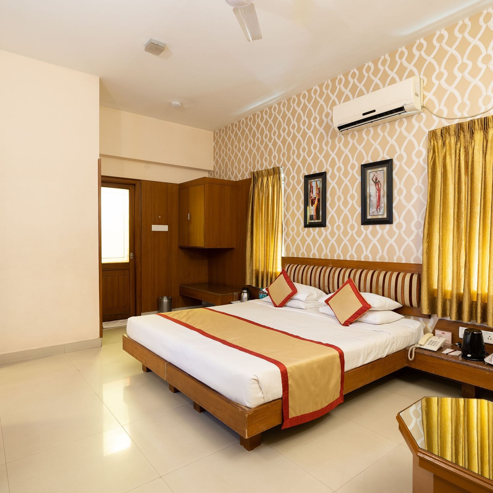 A double bed with a study table opposite it inside one of the rooms - Hotel Pai Vista, KR Road