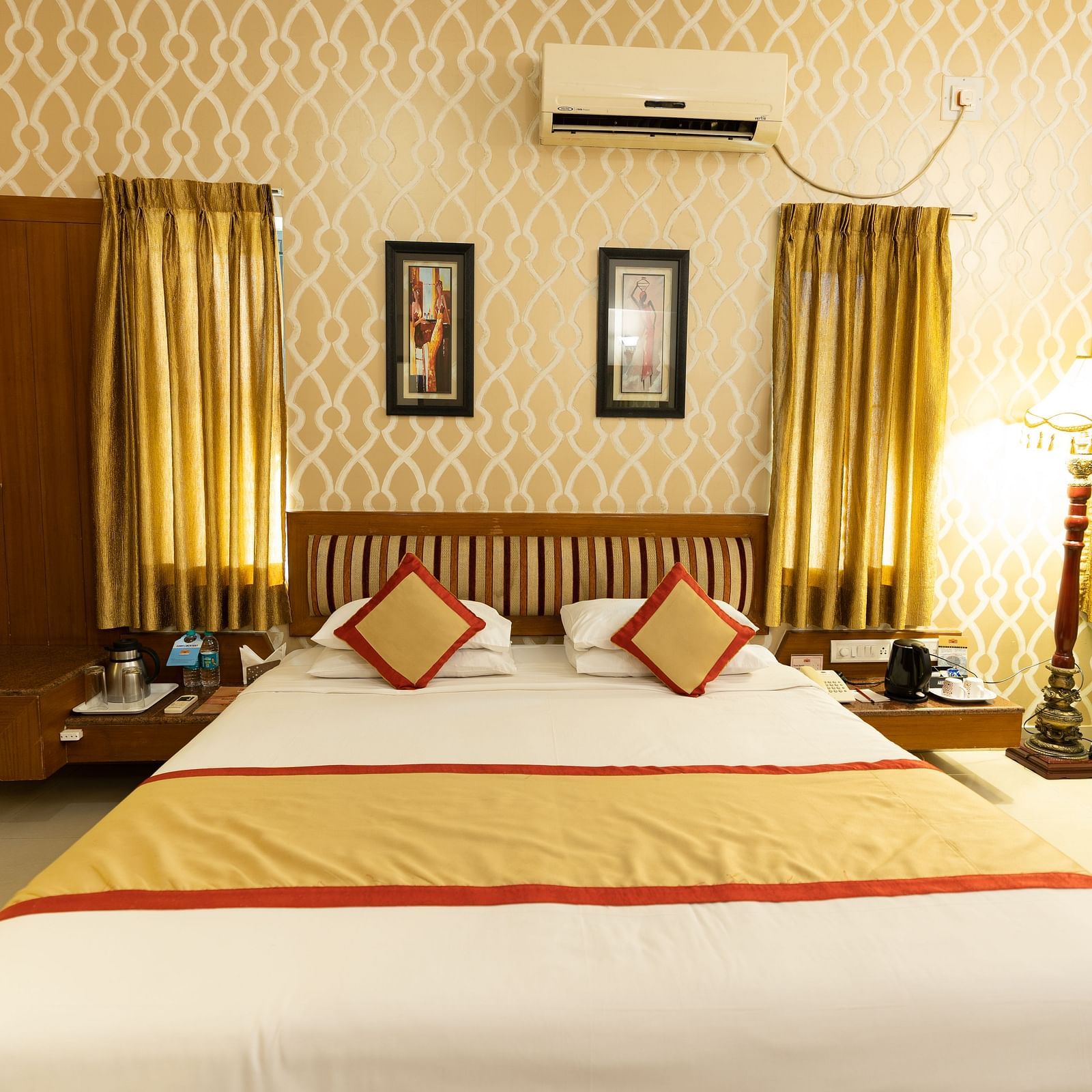 A double bed with side table and a lamp inside one of the rooms - Hotel Pai Vista, KR Road