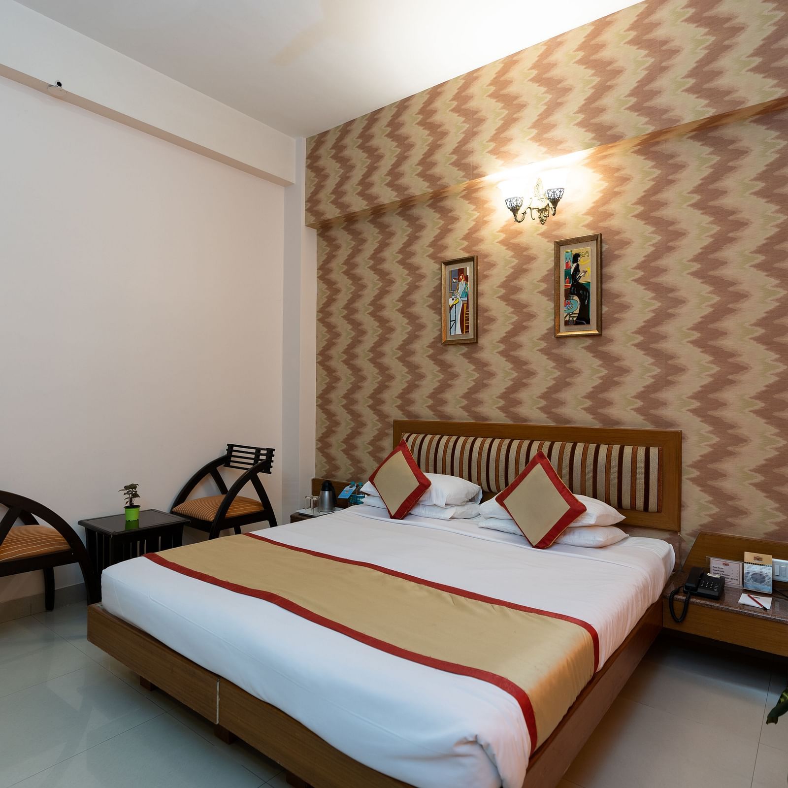 A double bed with chairs next to it inside one of the rooms - Hotel Pai Vista, KR Road
