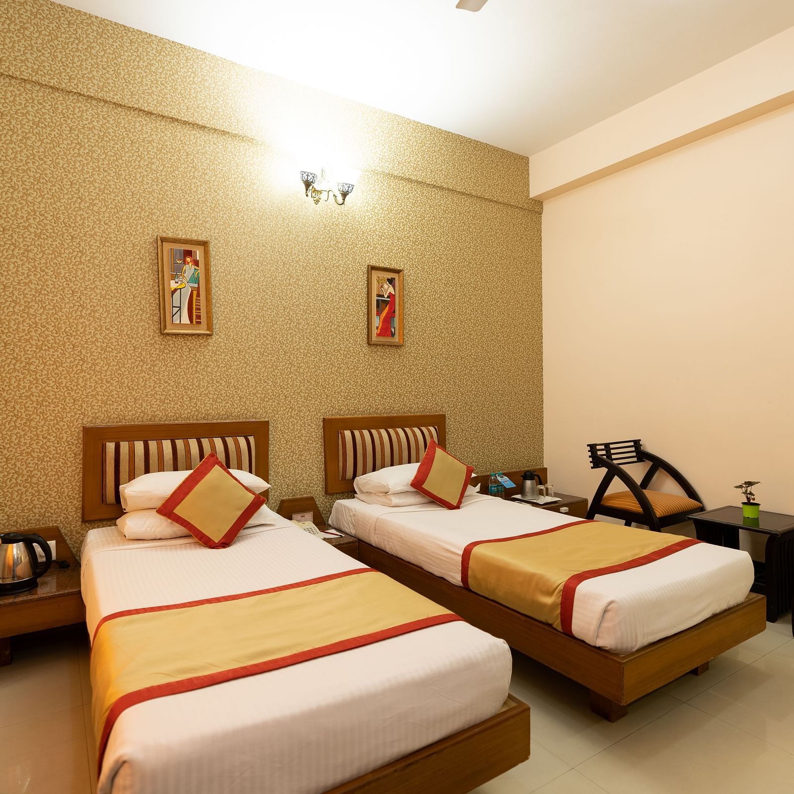 Twin bed with chairs next to it inside one of the rooms - Hotel Pai Vista, KR Road
