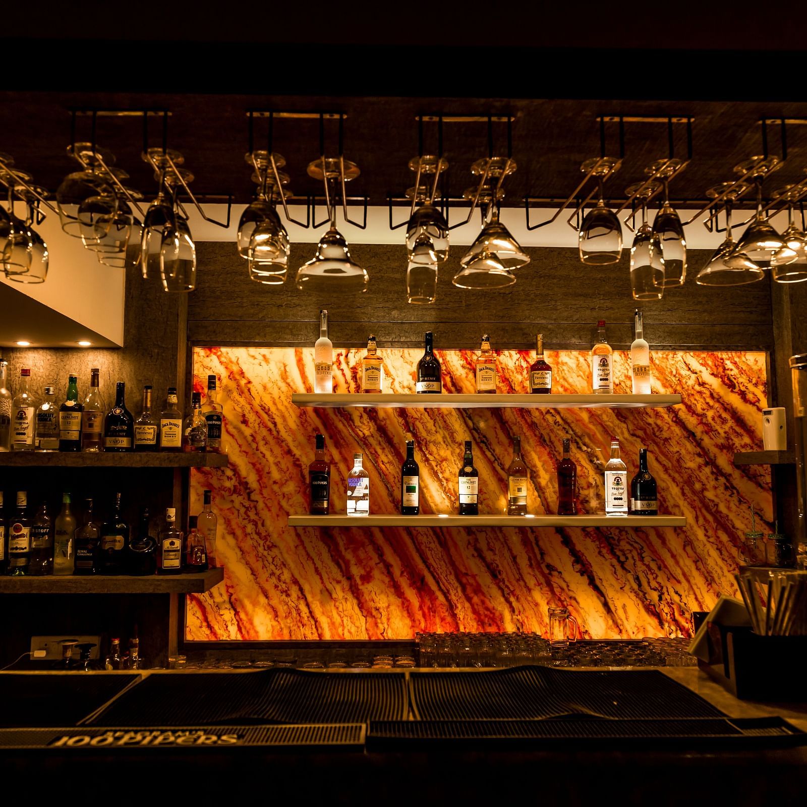 a bar counter with varieties of alcohol on display - Hotel Rockfort View, Trichy