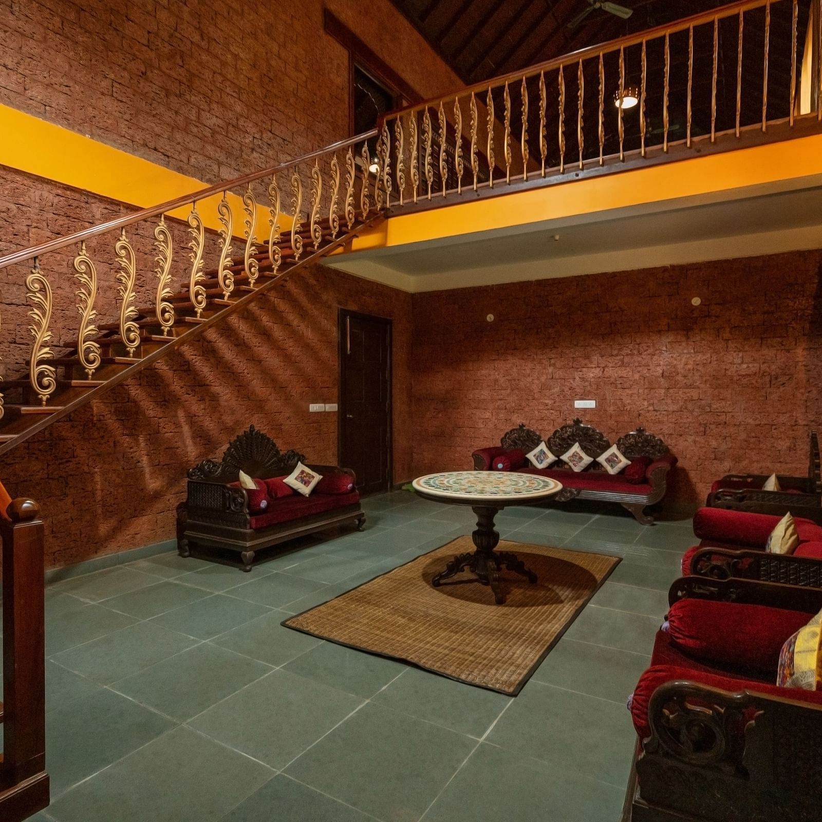 An image of a seating area and a flight of stairs on one side - Hoysala Village Resort,  Hassan