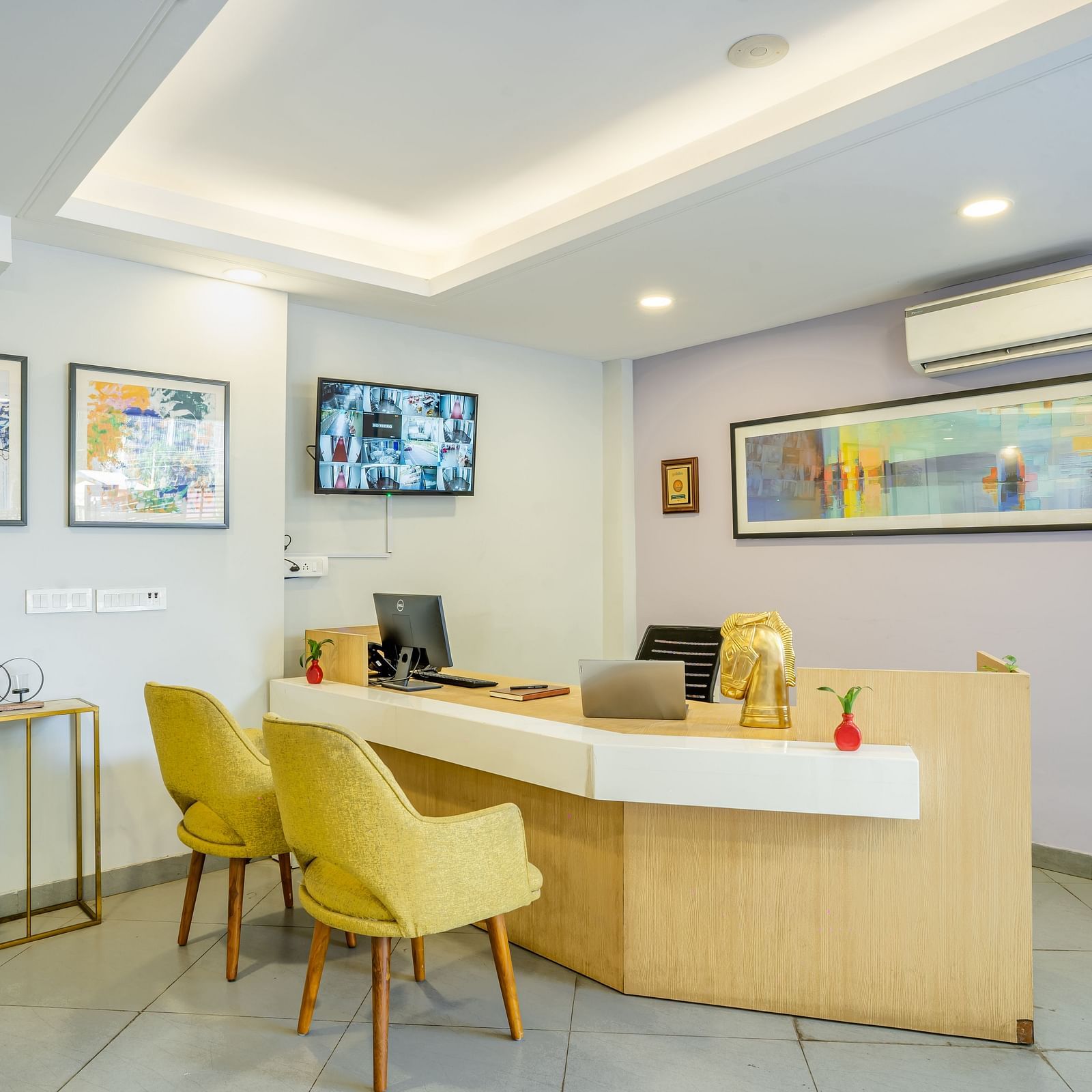 An image of a reception of the hotel where a desk and two chairs are placed | Inde Hotel Golf Course Extension