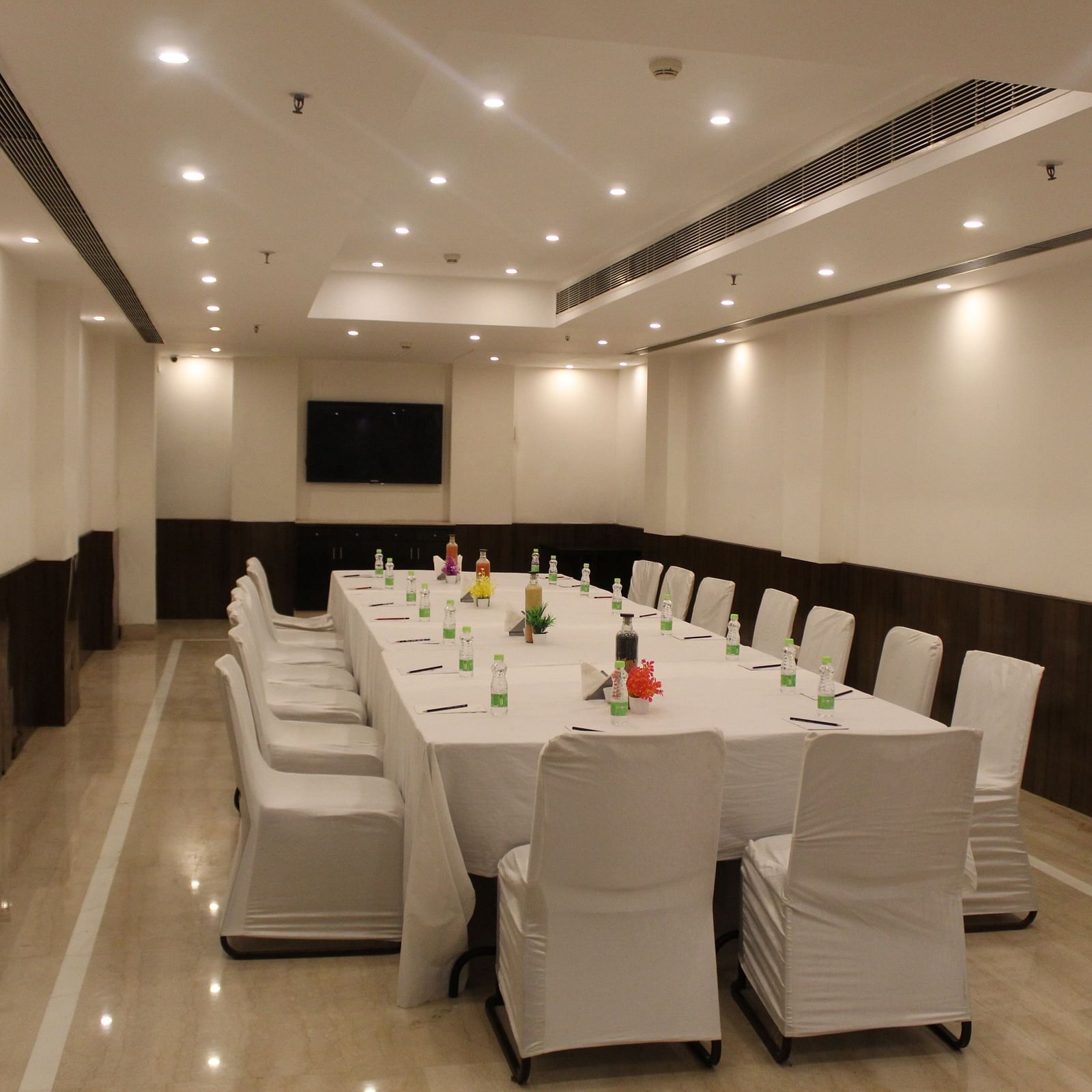 An image of a conference room at Inde Hotels Vista Woods featuring a huge table surrounded by several chairs