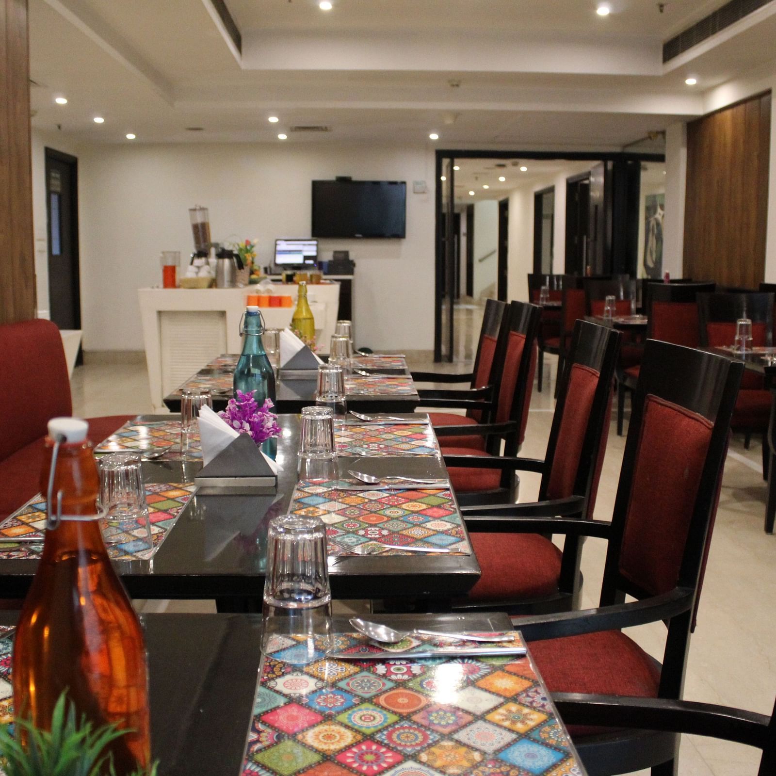 An image of a dining table with several chairs in a dining hall at Inde Hotels Vista Voods Gurgaon