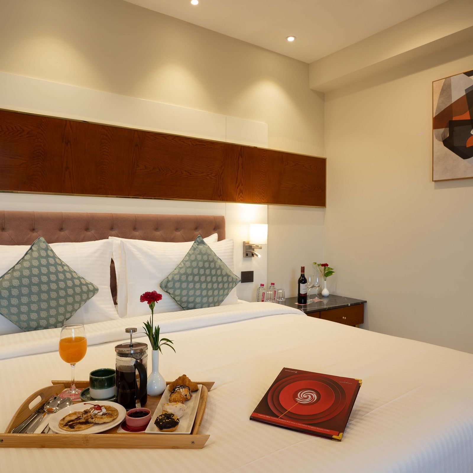 Club Room with a large double bed with decorative amenities artistically arranged at Inde Signature Jaipur.