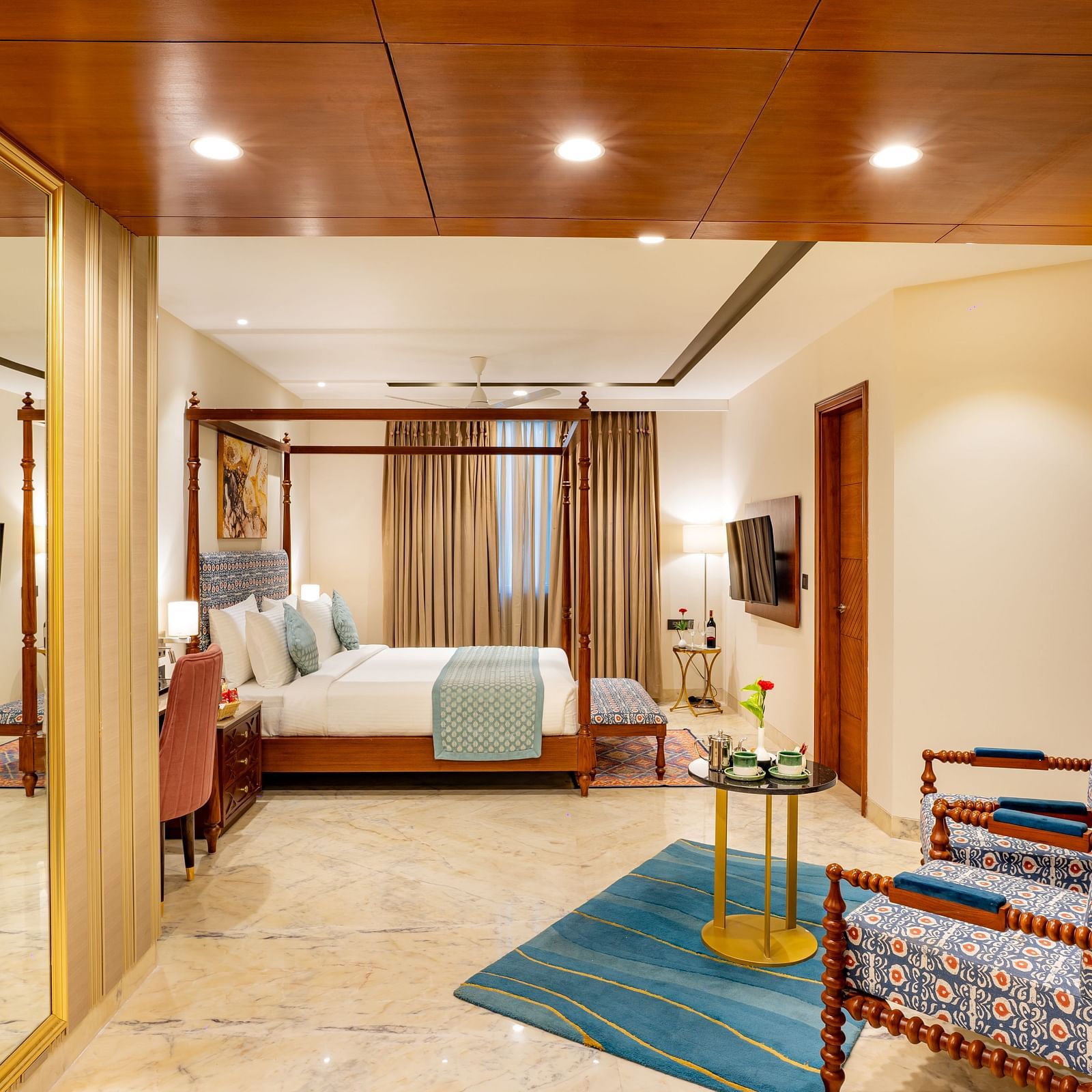 Spacious Suite with double bed, wooden bed side table, comfortable seating,wall mounted television, big window with curtains at Inde Signature Jaipur