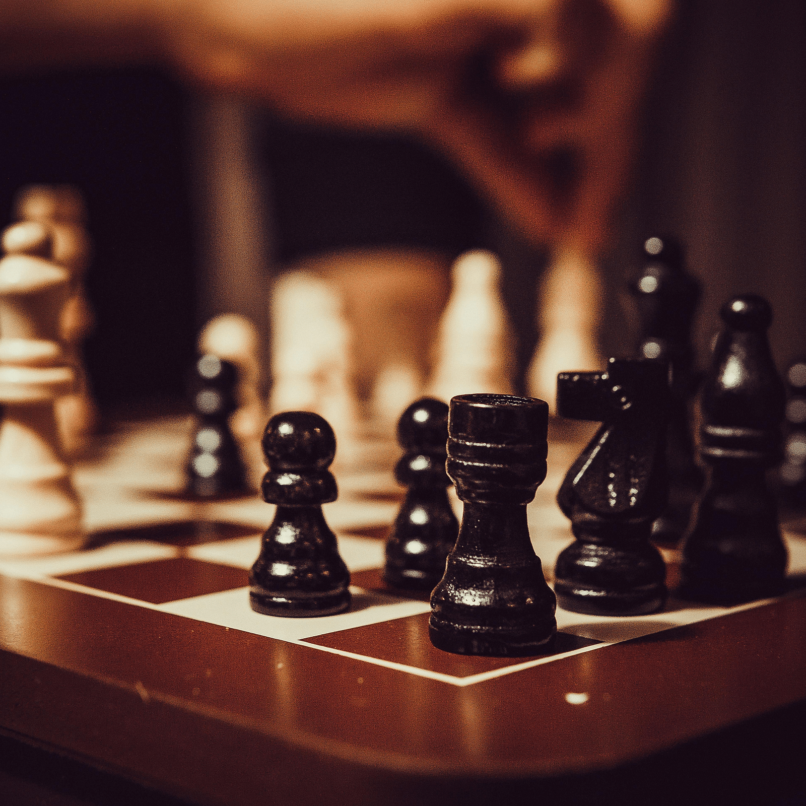  A wooden chessboard with chess pieces arranged on it, viewed from a diagonal angle