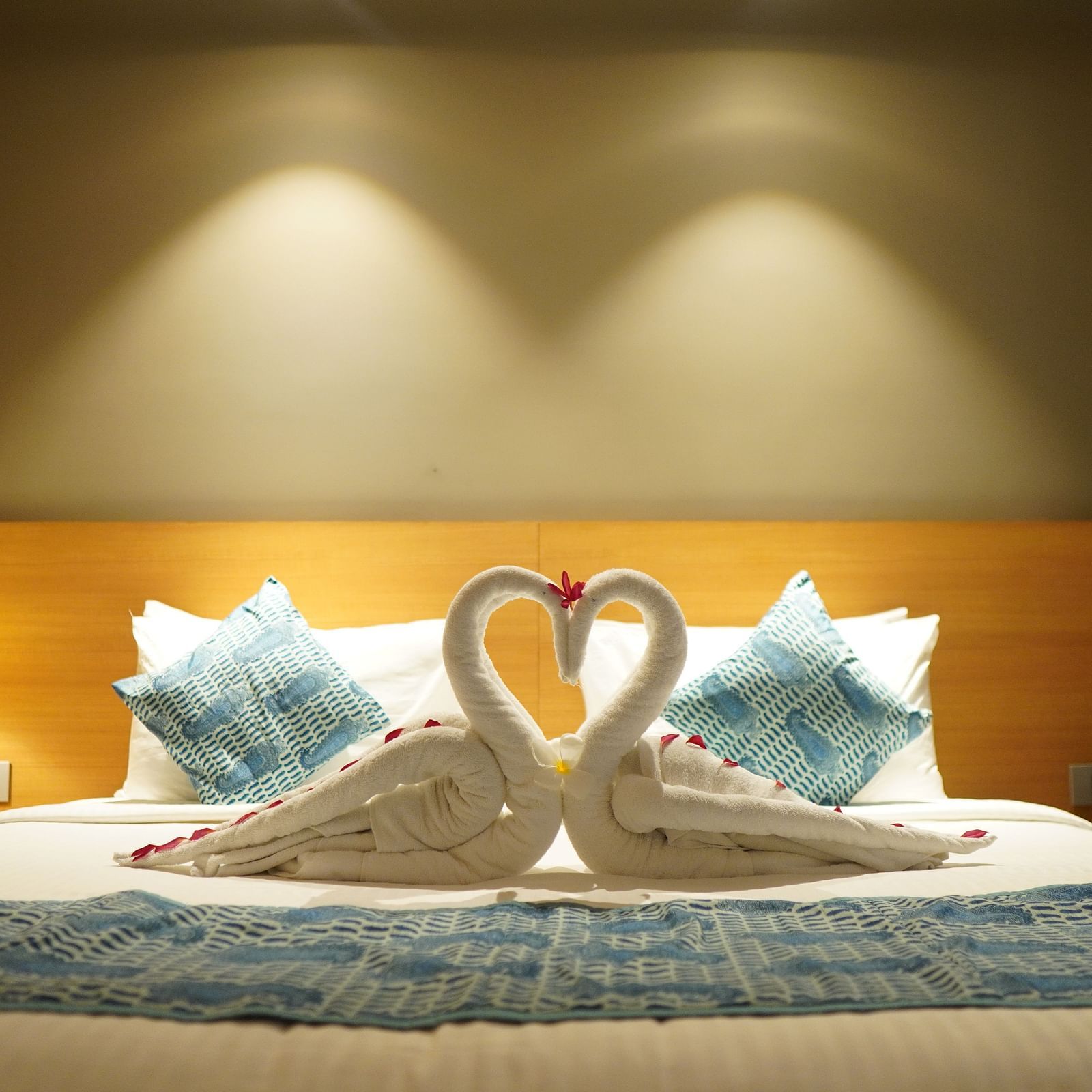 Spacious bed with towels folded into swans and warm lighting