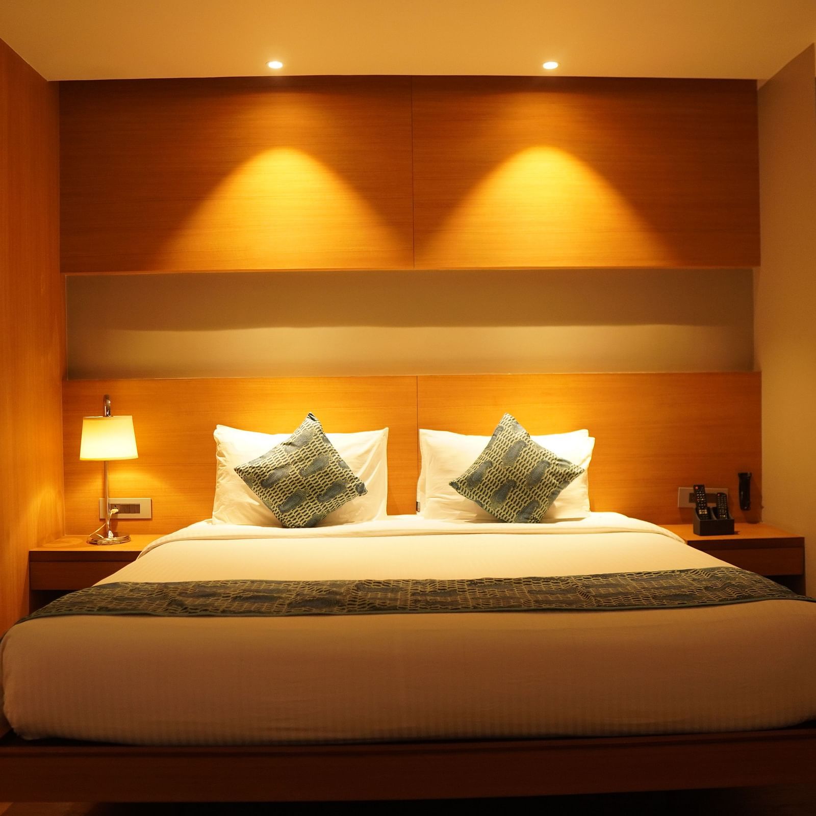 Front view of the bed with warm lighting and bedside tables on either side.