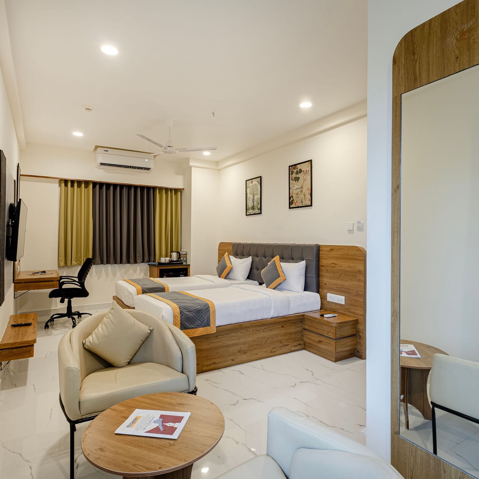 Stylish comfort twin room with soft lighting, seating area, and large bed at Lemonridge Hotels, IDPL Balanagar.